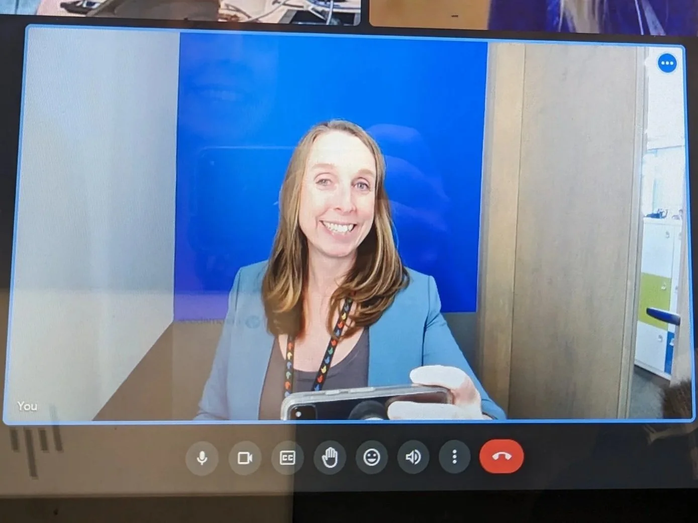 A video call showing three women, with two women in the top row and one woman in the bottom row. The women are smiling and appear to be in a professional or casual setting.