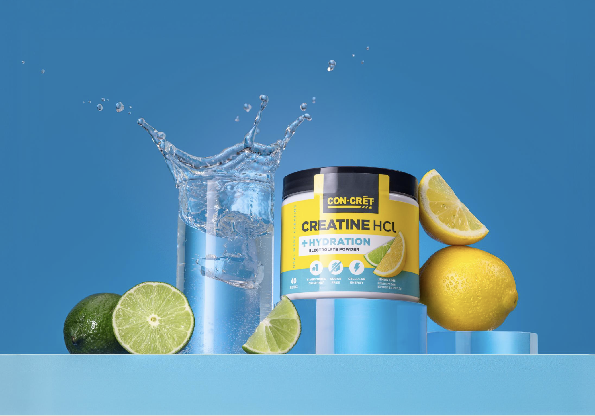 A container of Con-Cret Creatine HCL with hydration electrolyte powder, surrounded by fresh lemons and limes, and a glass of water with ice, with lemon slices on a blue background.