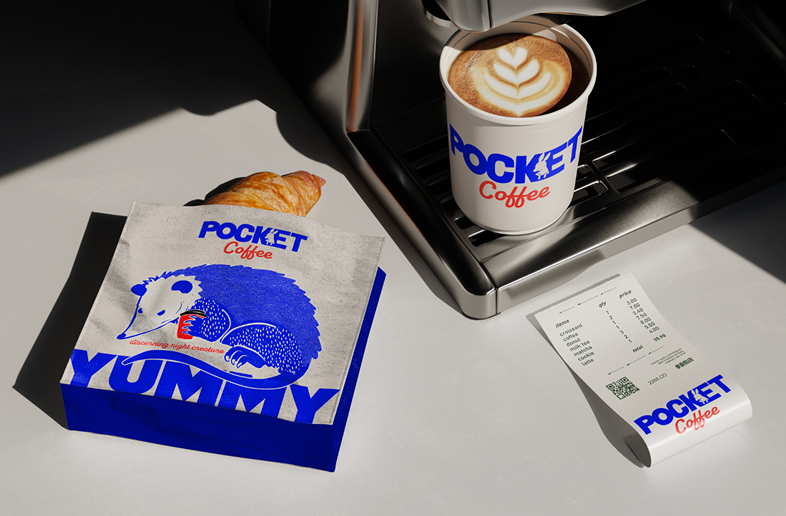 A cup of coffee with latte art on a coffee machine, a croissant on a paper bag with a unicorn illustration, and a receipt from Pocket Coffee.
