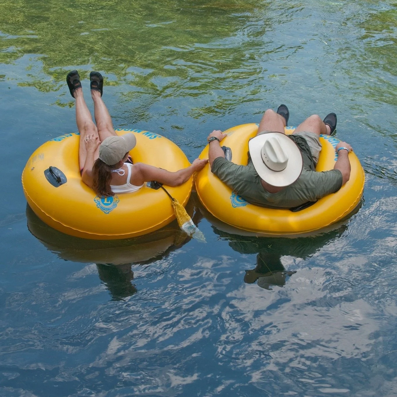 Couple enjoying a San Marcos River tube rental while floating downstream
