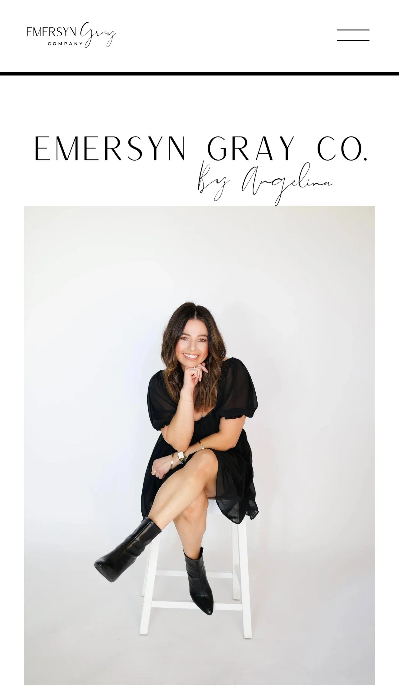 A woman sitting on a white stool, wearing a black dress and black boots, smiling, with a white background and minimal black text above her that reads 'Emersyn Gray Co. by Angelina'.