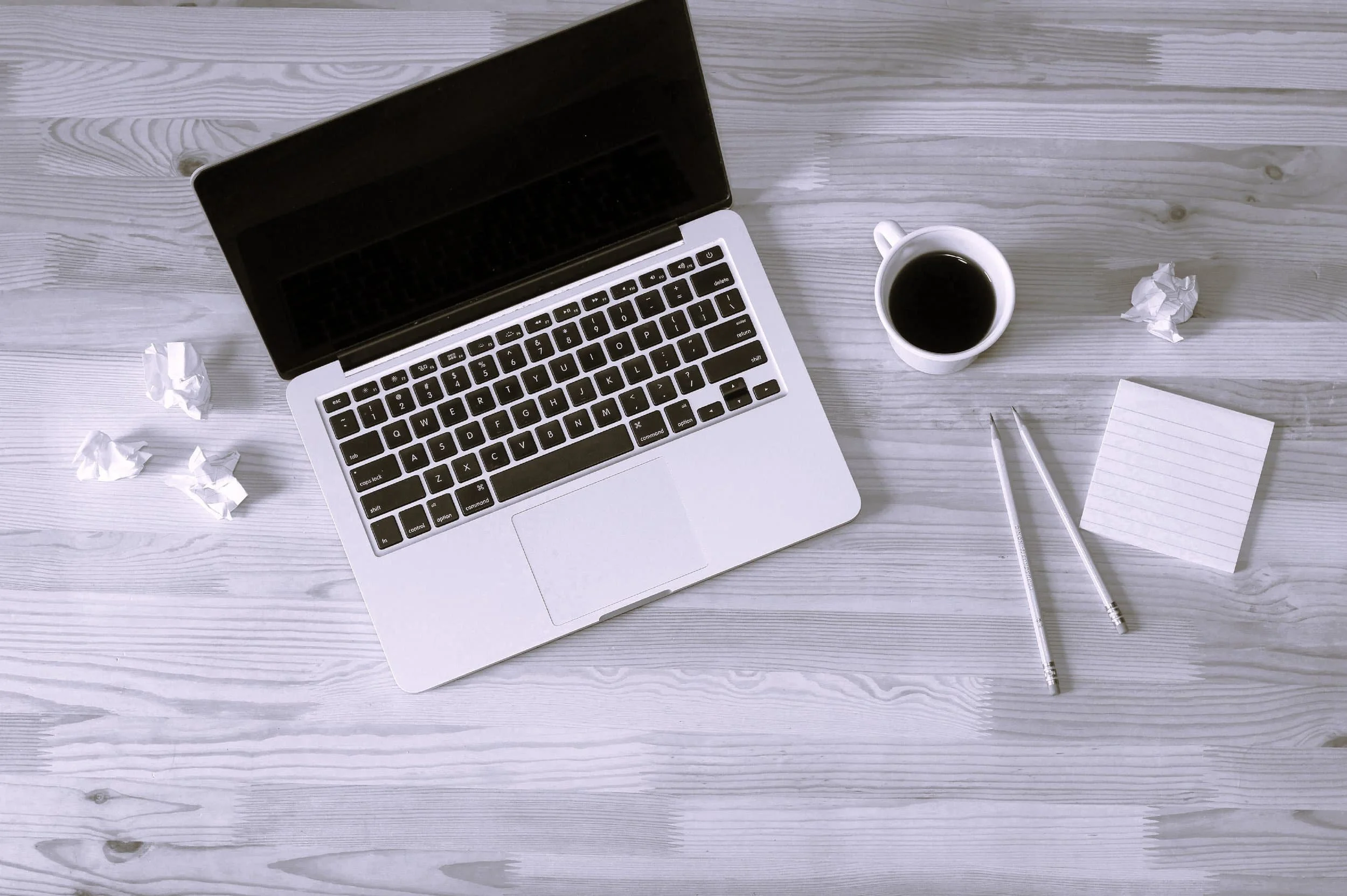 Computer and coffee sitting on a desk for a hairstylist web designer