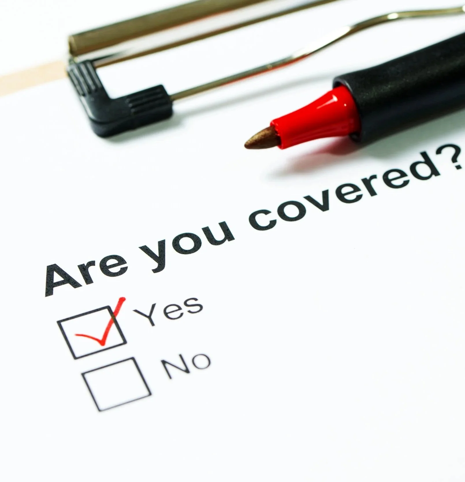 A printed survey question asking, "Are you covered?" with checkboxes for "Yes" and "No." The "Yes" box is checked with a red marker. There is a red marker and a black highlighter lying on the paper.