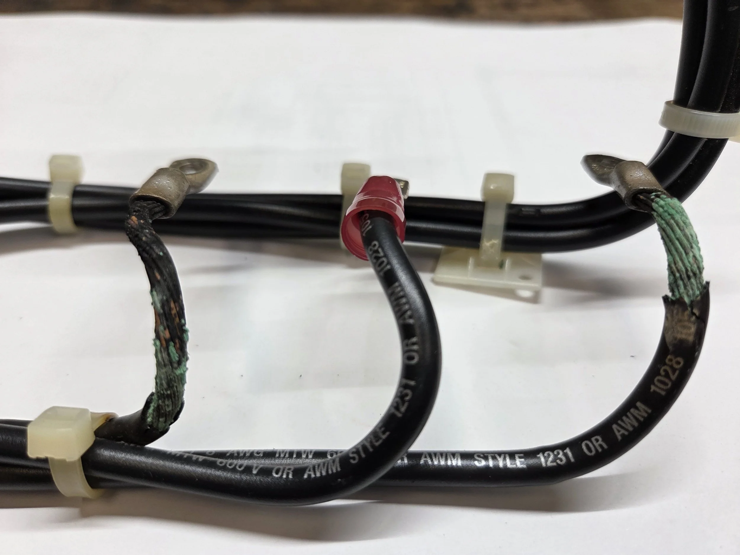 Close-up of damaged electrical wires with frayed insulation and corrosion, connected to a bundle of black cables secured with cable ties. Thermograpics. Thermograpy.  Unseen electrical problems. Hot wire. Hot contacts. Resistance at termination.