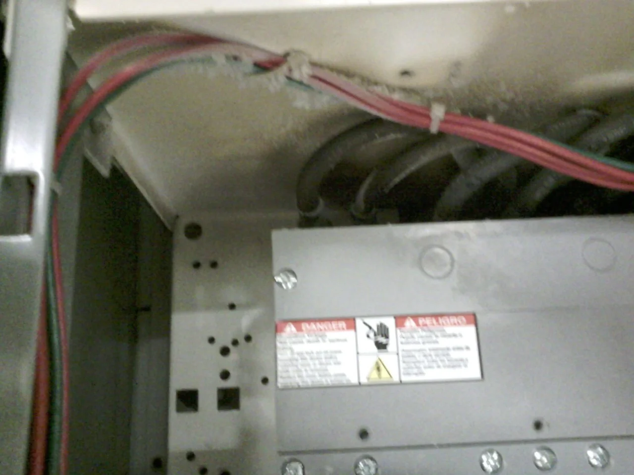 Inside view of an electrical panel with wires and circuit breakers, warning label present. Thermograpics. Thermograpy.  Unseen electrical problems. Hot wire. Hot contacts. Resistance at termination. Loose terminations.