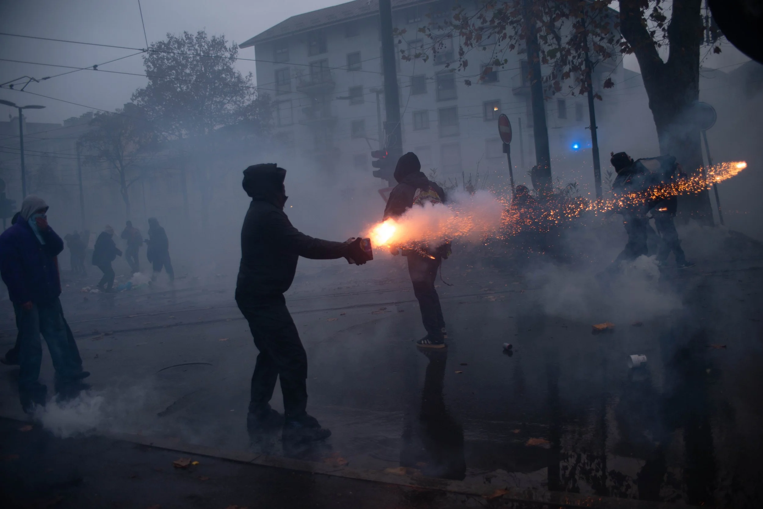 Turin, Italy – December 20, 2025: Shrouded in thick smoke, protesters fire pyrotechnics during running street battles with police after the eviction of the Askatasuna social center.