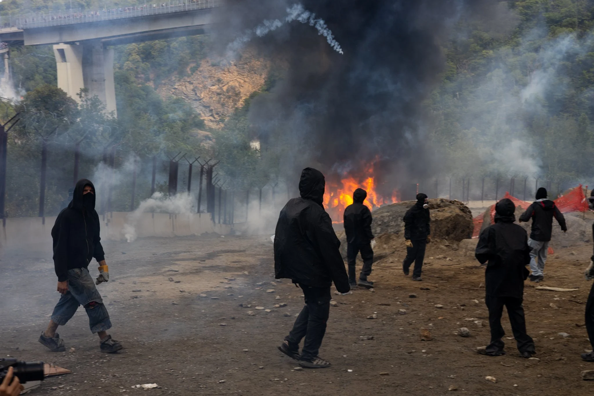 Chiomonte, Italy – July 25, 2026: No Tav protests: Black Bloc members throw stones at burning Carabinieri vans at the Chiomonte construction site