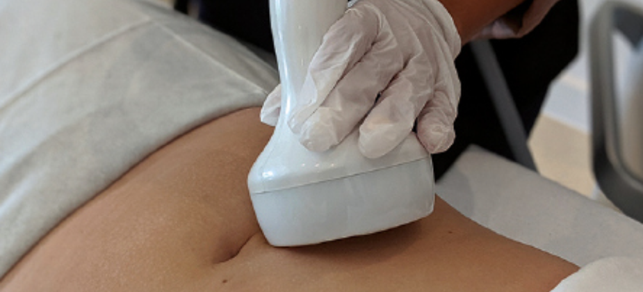Medical professional performing an ultrasound on a patient's abdomen.