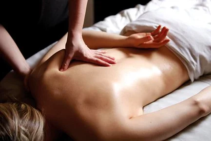 Person receiving a back massage on a massage table.