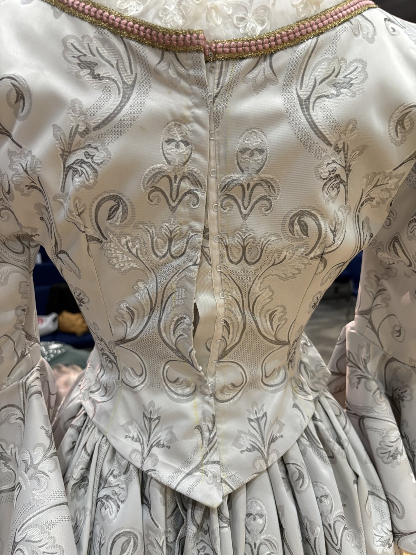 The back view of the fitted bodice showcases intricate jacquard fabric and delicate trim, emphasizing the romantic period style created for period episode in TV soap opera Passions.