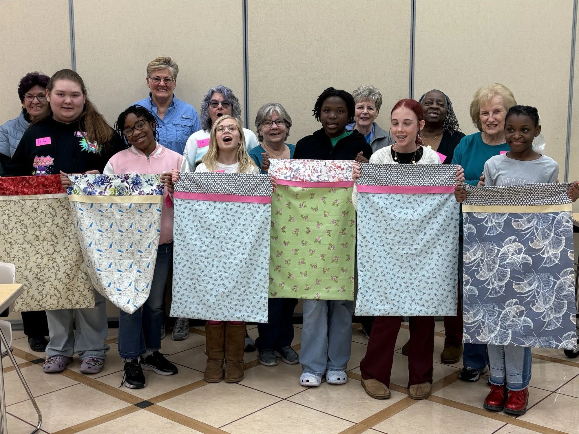 Girl Scouts present their project, a pillow case from the sewing class hosted by the LVQG.