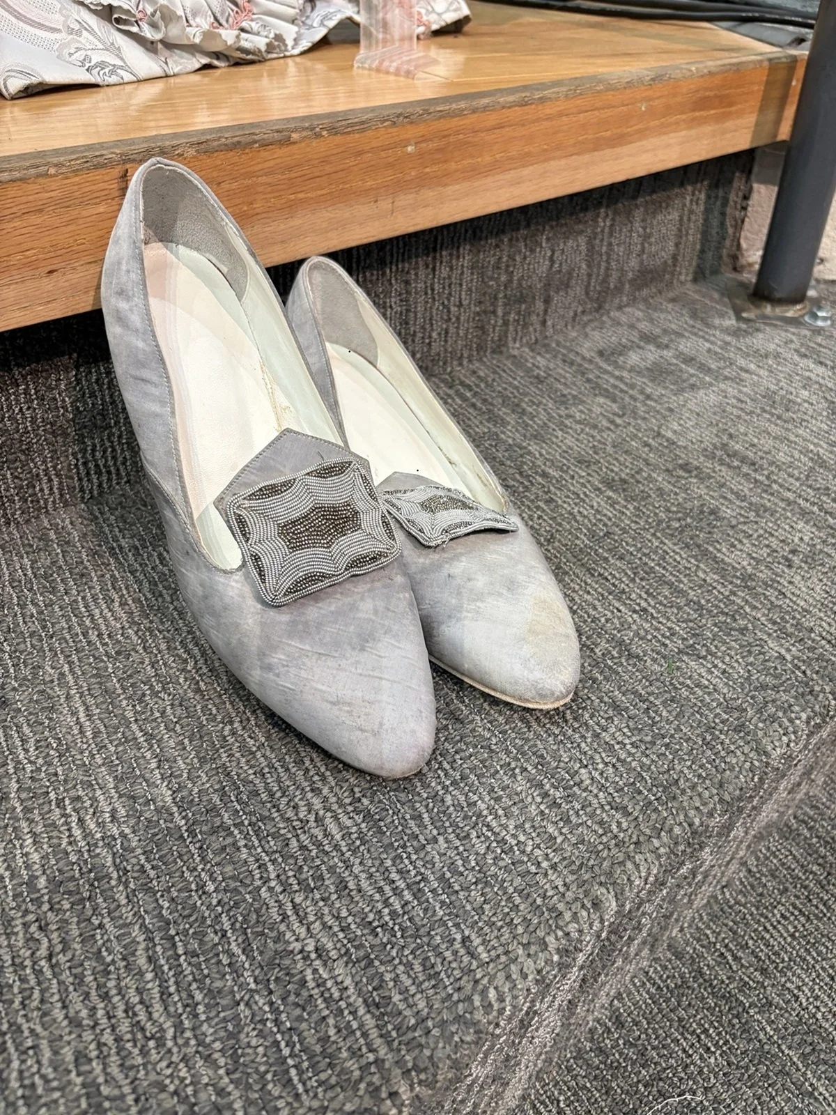 Elegant satin shoes with decorative buckles worn with the costume, complementing the gown’s refined period aesthetic.