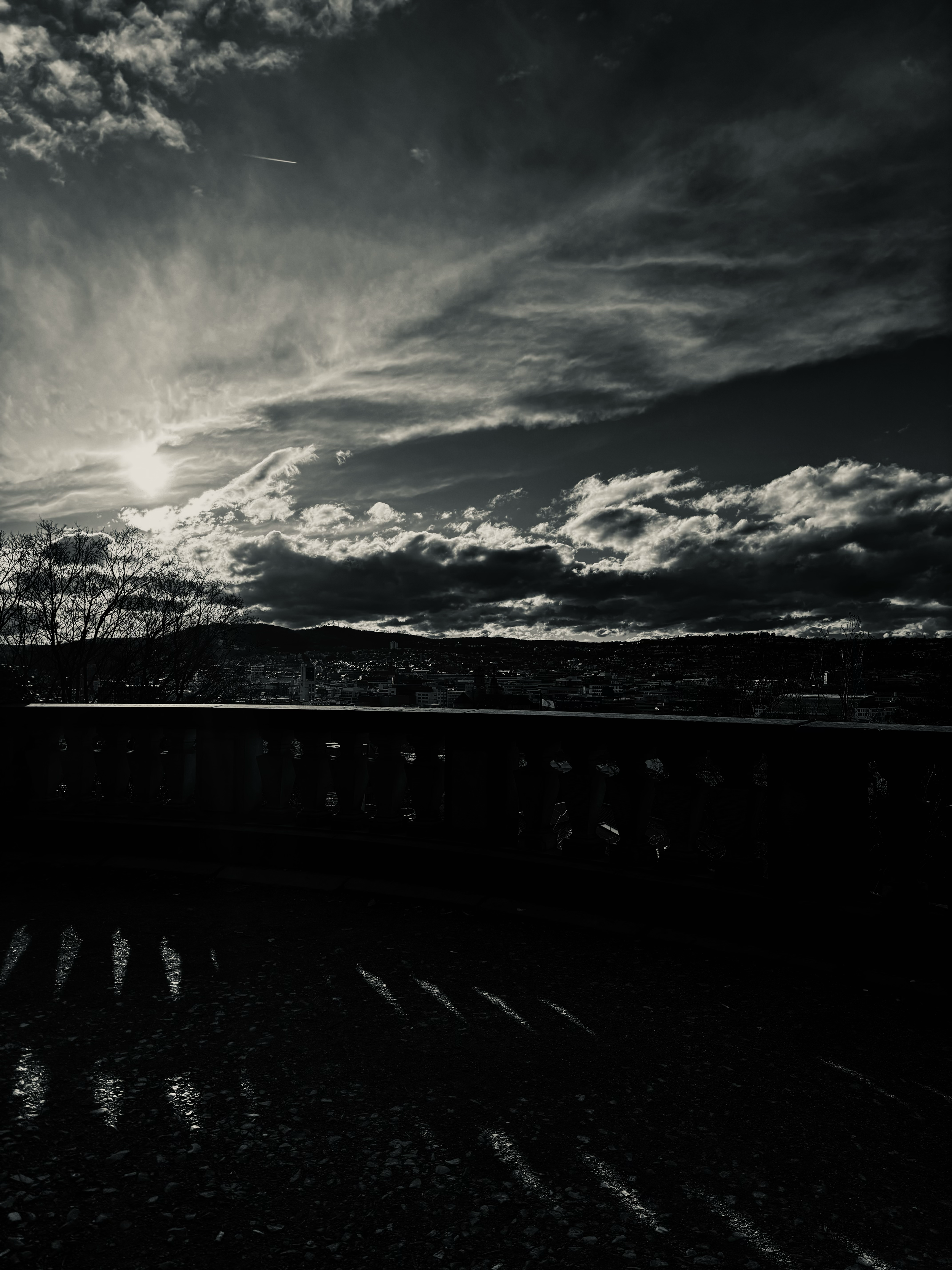 A dramatic sky with striking cloud formations illuminated from behind, captured above a fence in Stuttgart, creating a powerful and moody atmosphere. Ein dramatischer Himmel mit markanten Wolkenformationen, von hinten beleuchtet, über einem Zaun in S