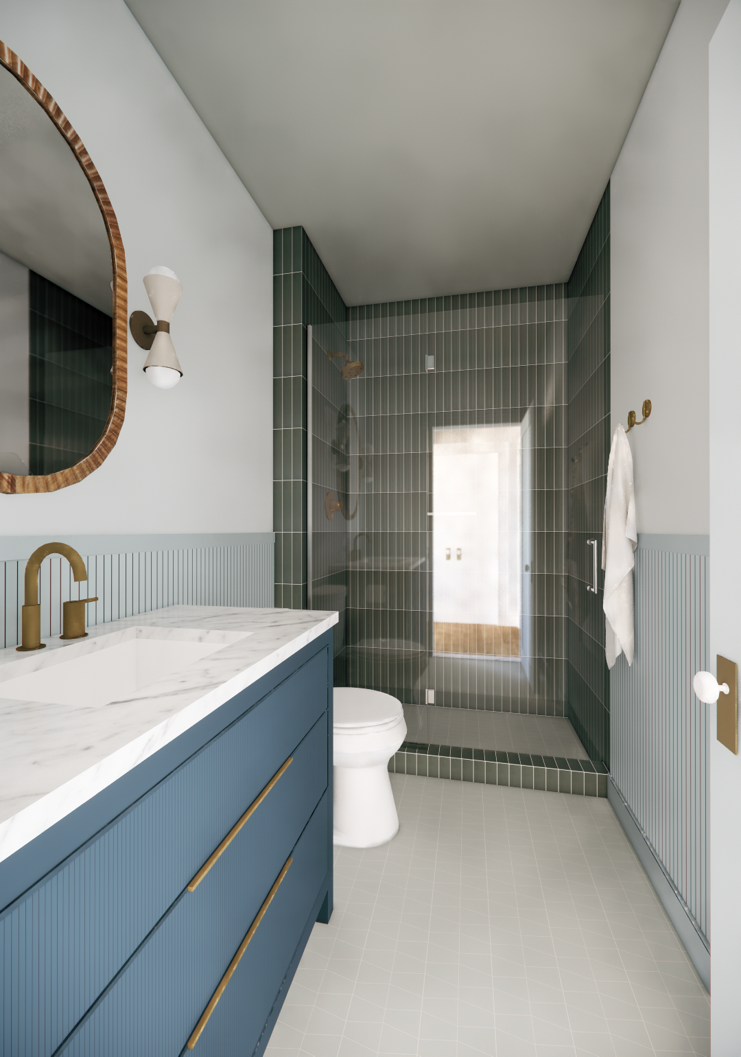 Modern bathroom with light blue vanity with brass handles, marble countertop, brass faucet, large mirror with wooden frame, wall-mounted light fixture, toilet, and a glass-enclosed walk-in shower with dark green tiles.