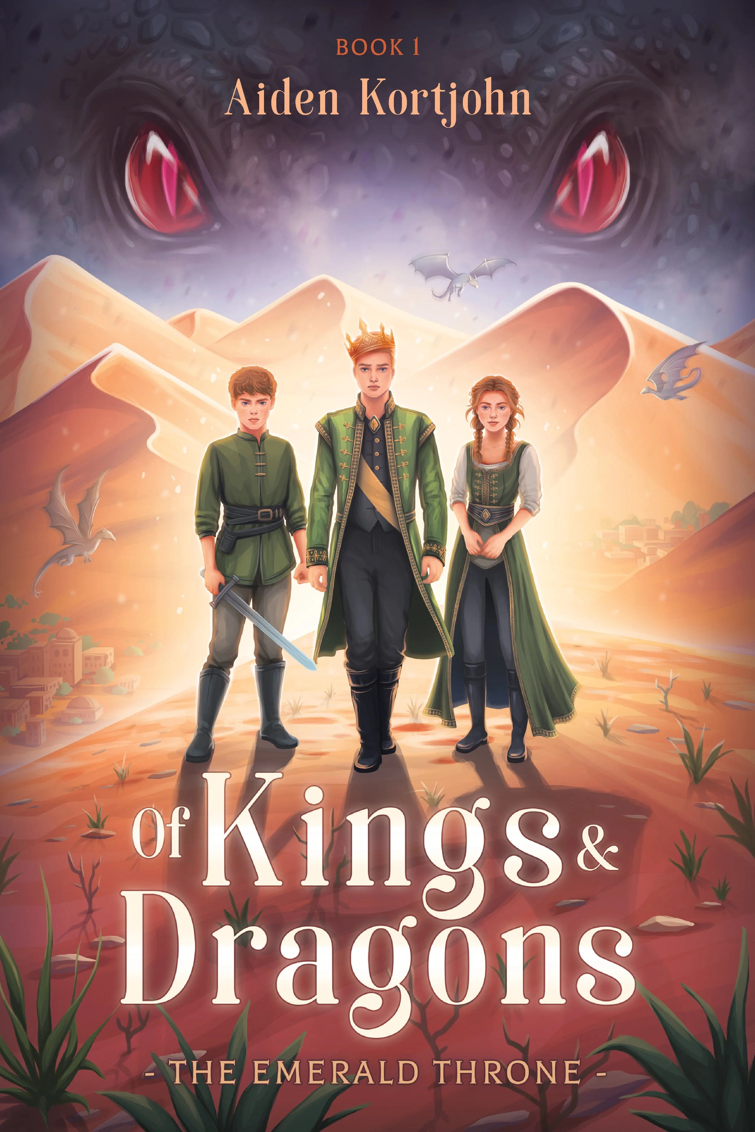 Three young characters dressed as royalty and warriors standing on a desert landscape with ancient mountains, large eyes of a dragon in the sky, flying dragons, and small dragons surrounding them. The top text reads 'Book 1 Aiden Kortjohm' and the bottom text reads 'of Kings & Dragons - The Emerald Throne'.