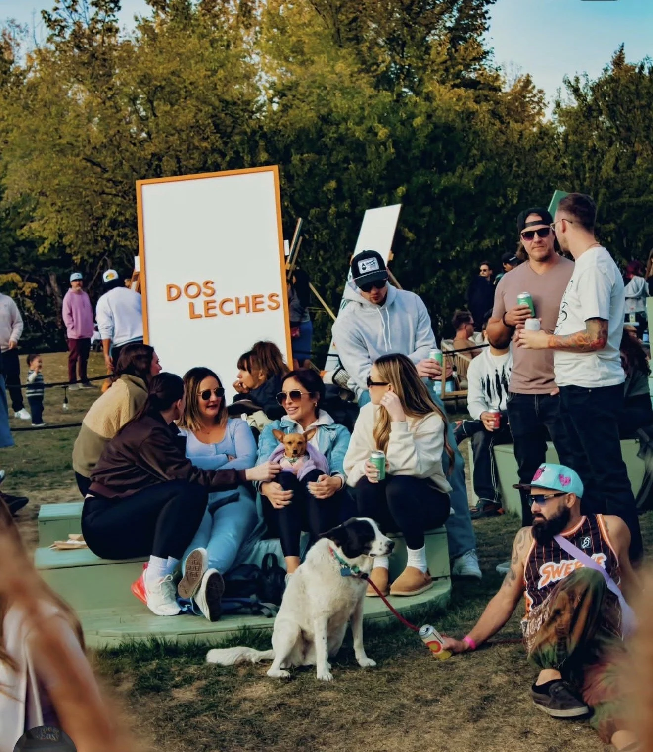 Community members gathered on the grass at a Dos Leches outdoor event in Calgary