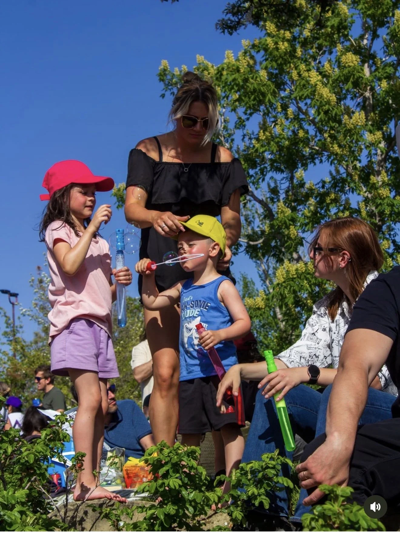 Kids blowing bubbles at the Dos Leches kids' area during a free outdoor event in Calgary