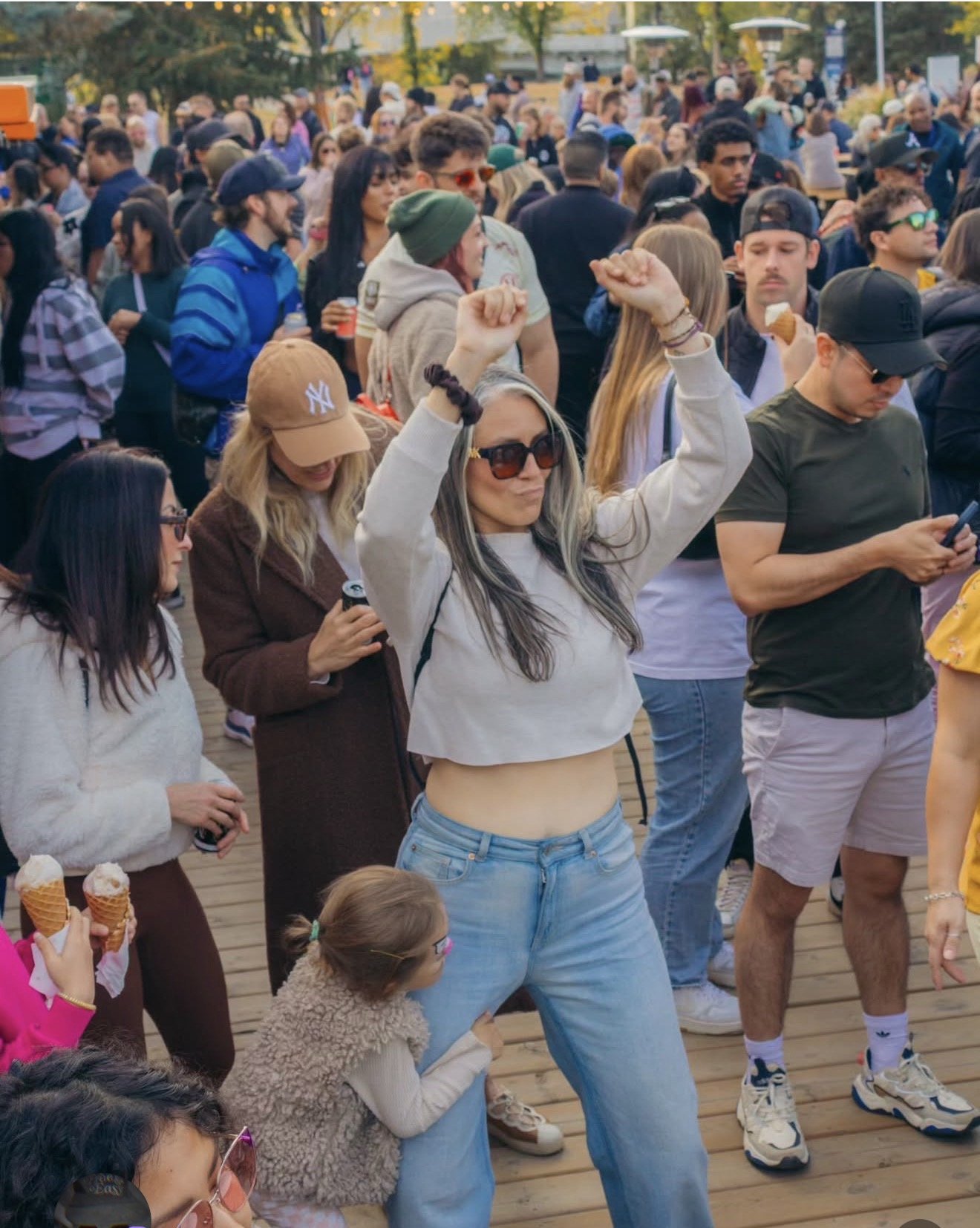 Friends dancing together at a Dos Leches community gathering in a Calgary park