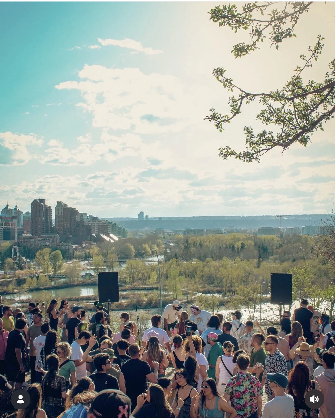 Dos Leches free outdoor event in Calgary with crowd gathered near the Bow River at sunset