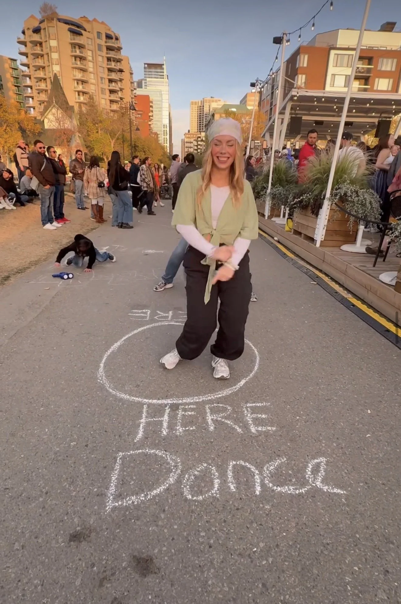 Woman dancing inside a chalk circle at a Dos Leches outdoor event in Calgary