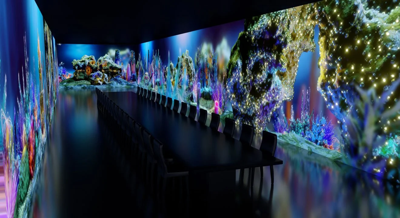 Indoor room with colorful digital underwater coral reef mural and a long black conference table with chairs.