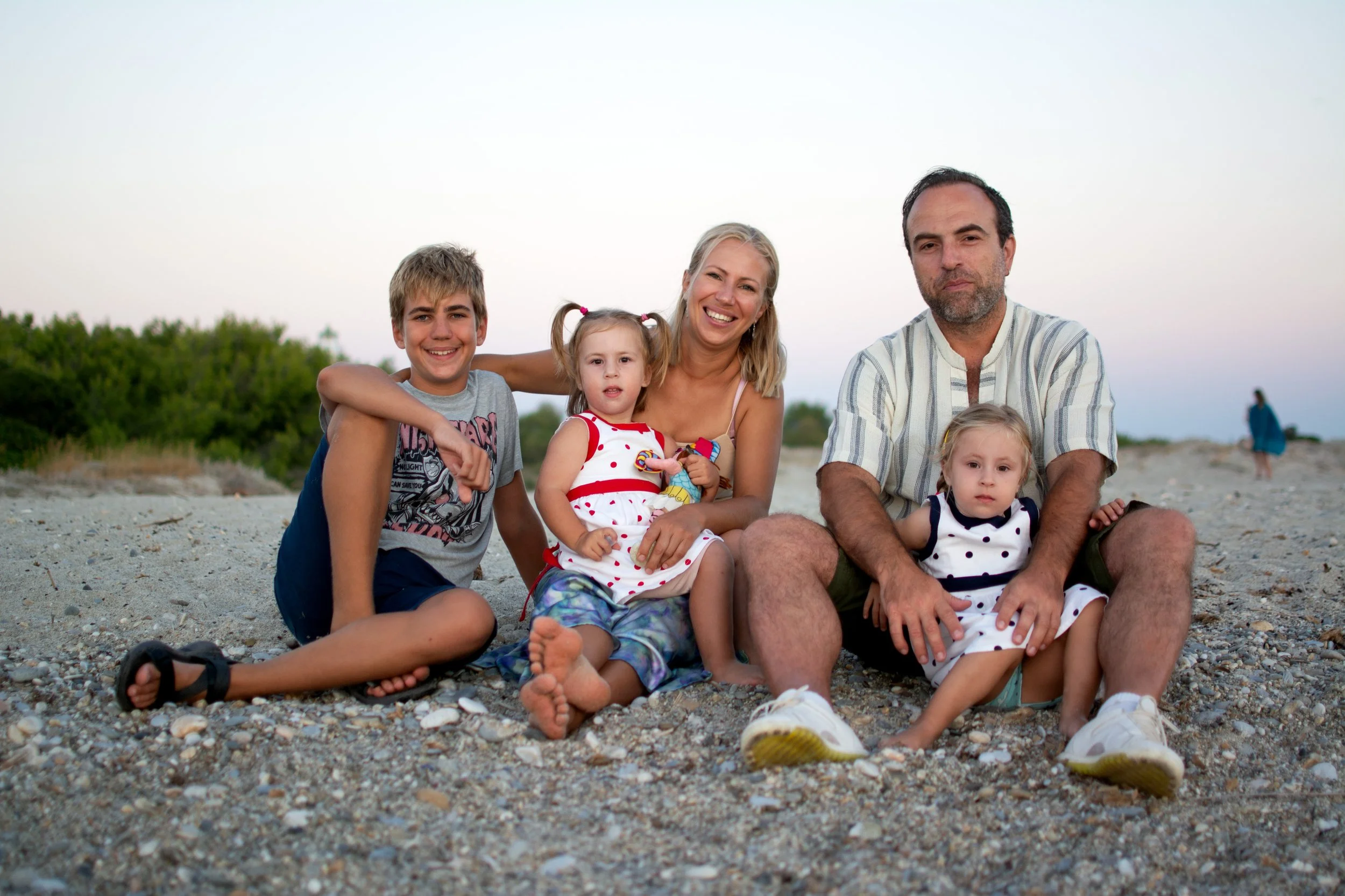 Familie op het strand tijdens een familiefotoshoot, natuurlijke emoties en licht