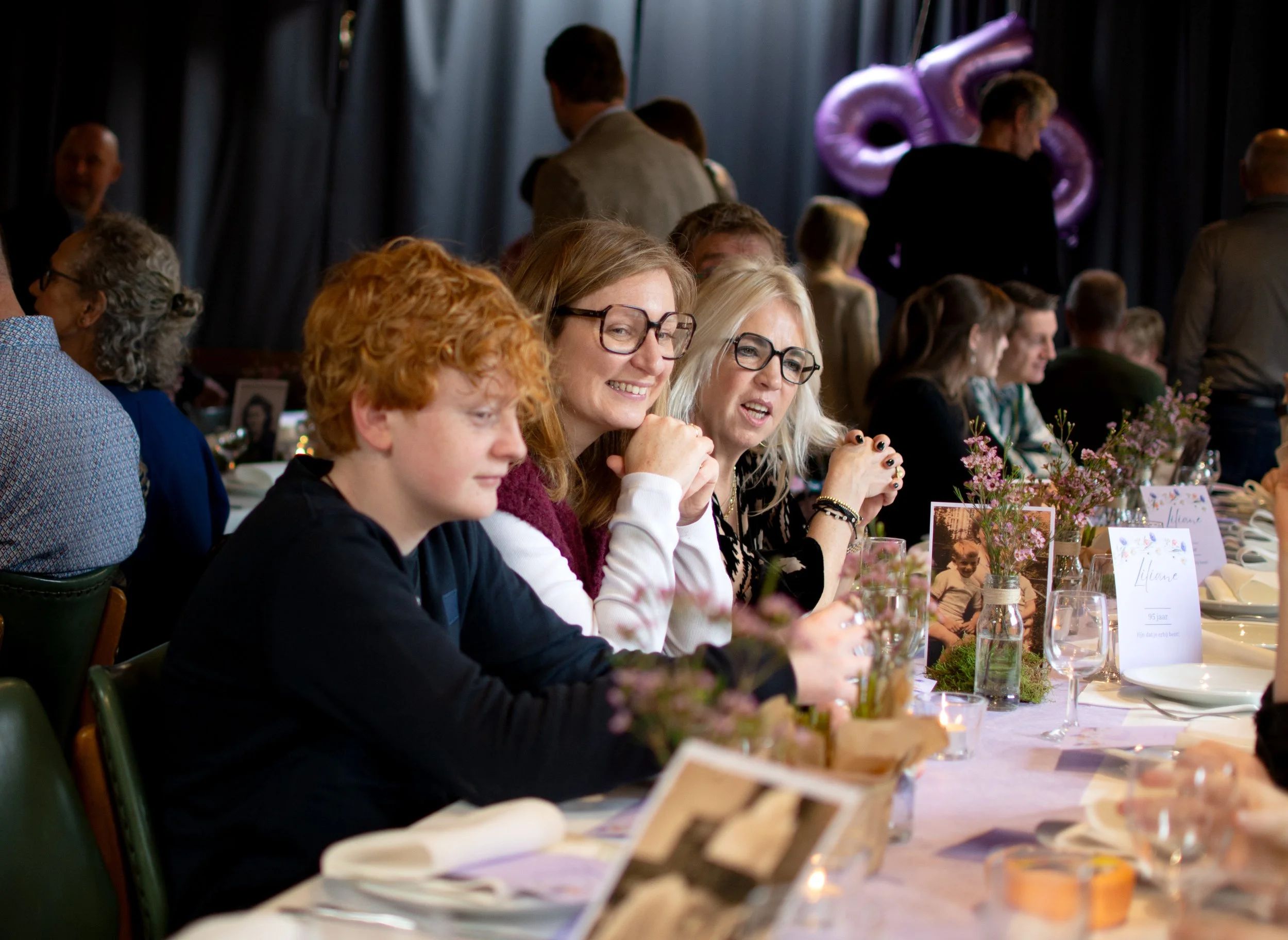 People sitting at a decorated table during a celebration or event.