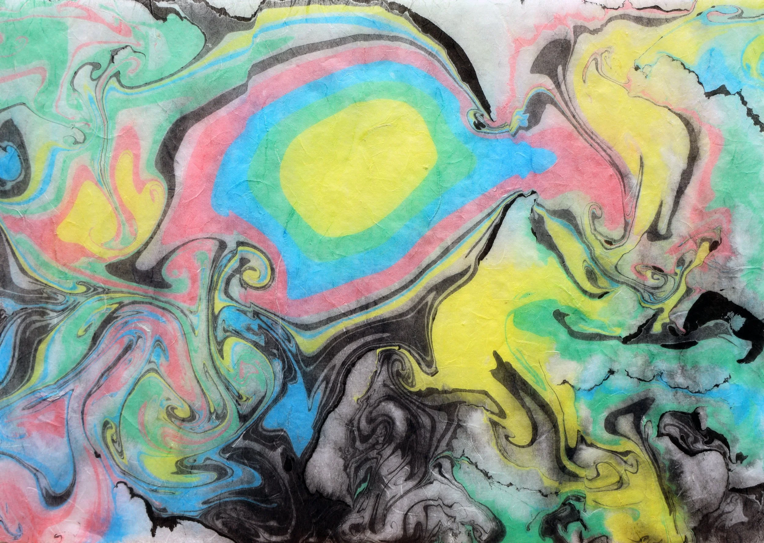Colorful abstract marbled paper with swirling patterns of yellow, pink, blue, green, black, and gray.