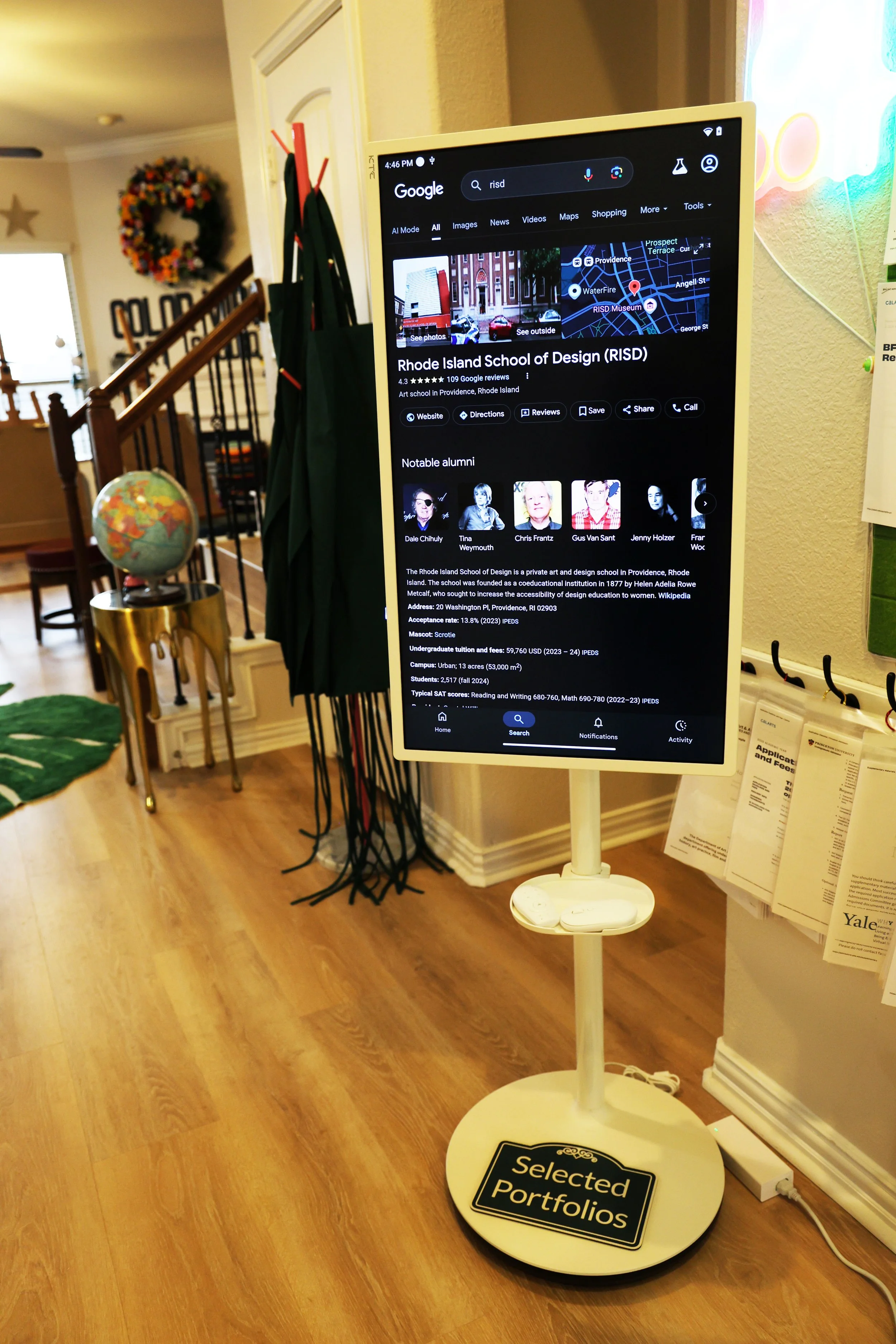 Digital display screen showing information about Rhode Island School of Design (RISD) at an educational institution's lobby or reception area. The screen displays the school's name, location, notable alumni, website links, and other details.