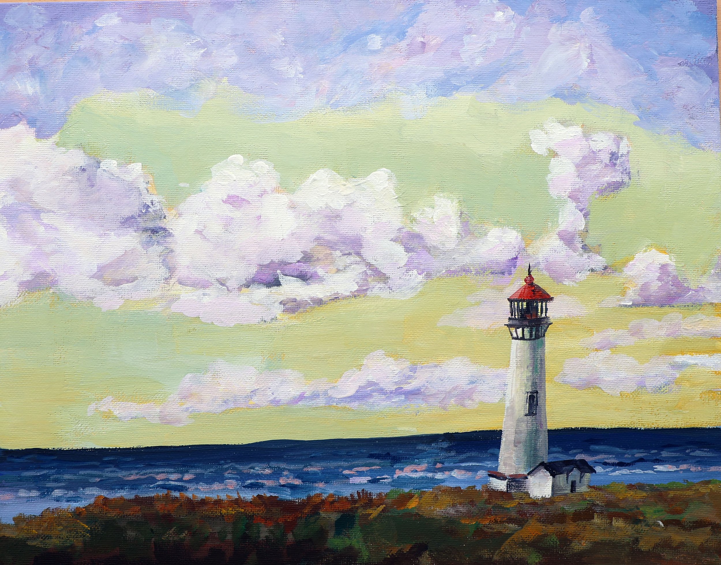 A lighthouse on a green and rocky shoreline with a stormy sky filled with large, billowing clouds