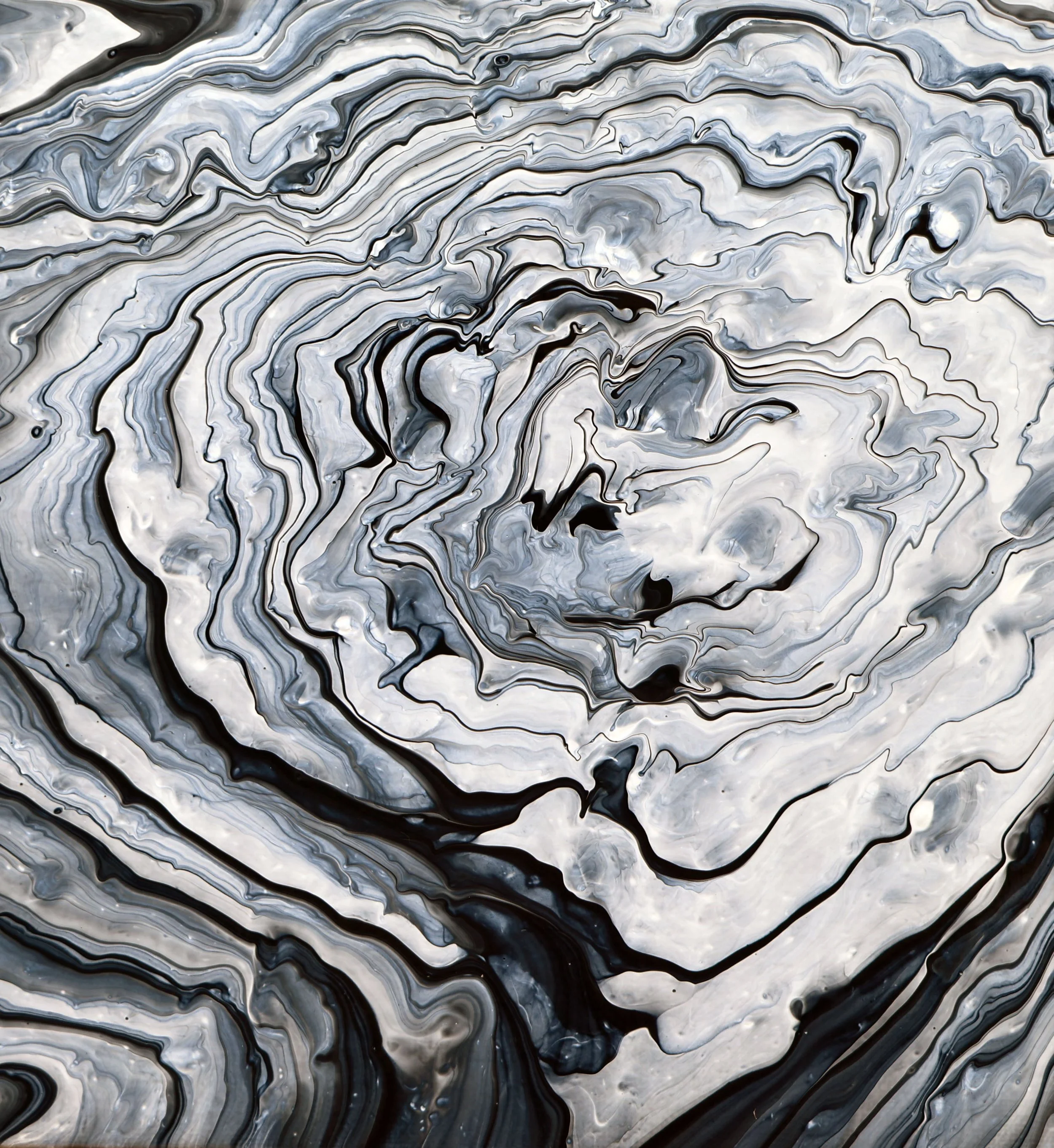 Abstract black, white, and gray swirling marbled pattern with fluid, wavy lines.