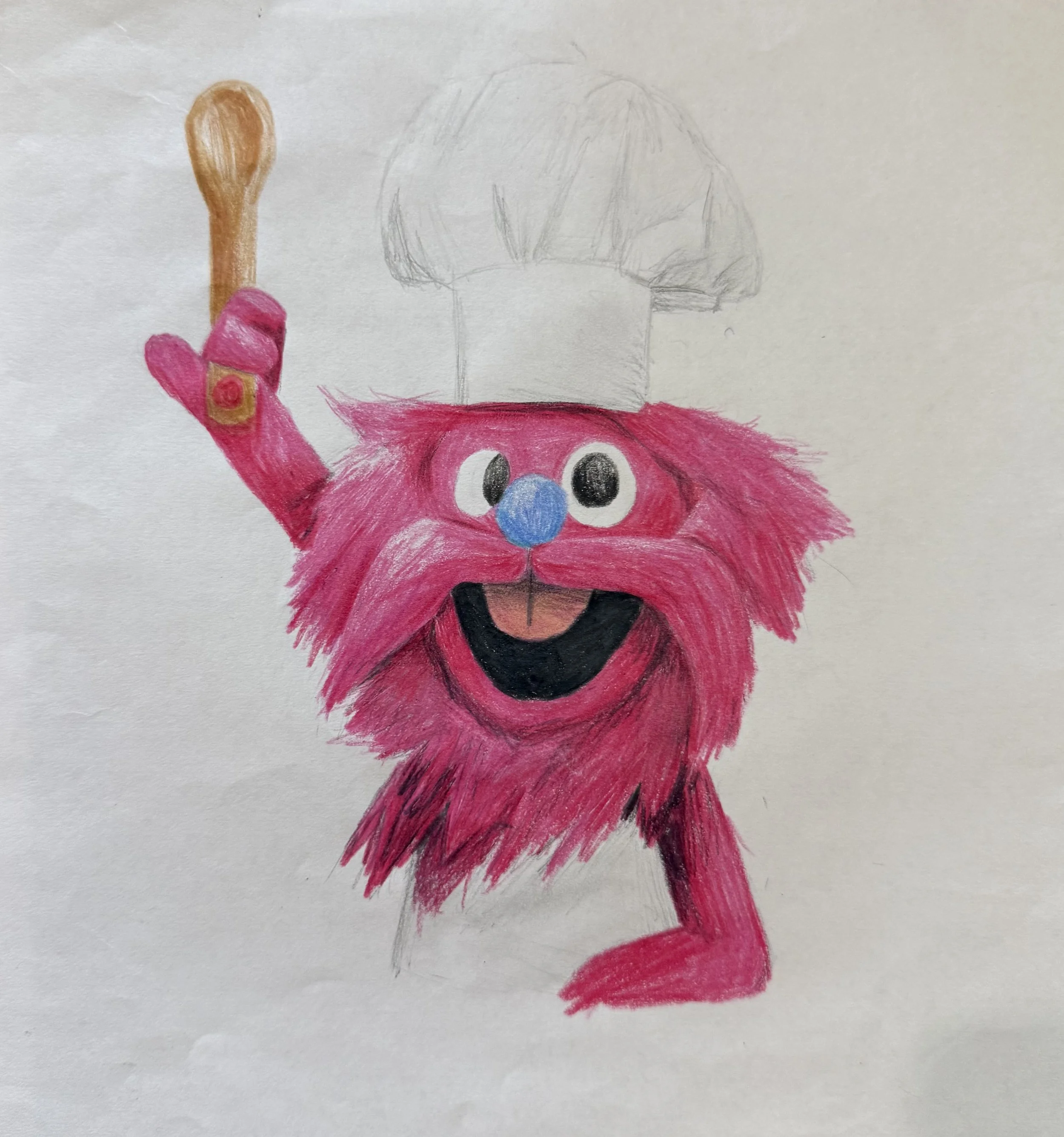A child's drawing featuring a character with a pink furry face, large eyes, a blue nose, and a wide black mouth. The character is holding a beige spoon and is dressed in red. There is a faint pencil sketch of a mushroom above the character's head.