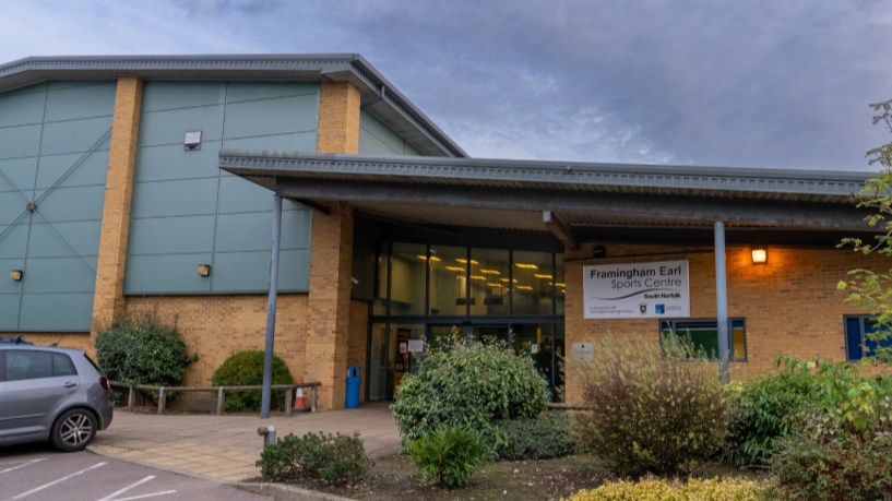 Exterior view of Framingham Earl Sports Centre with parking lot and greenery