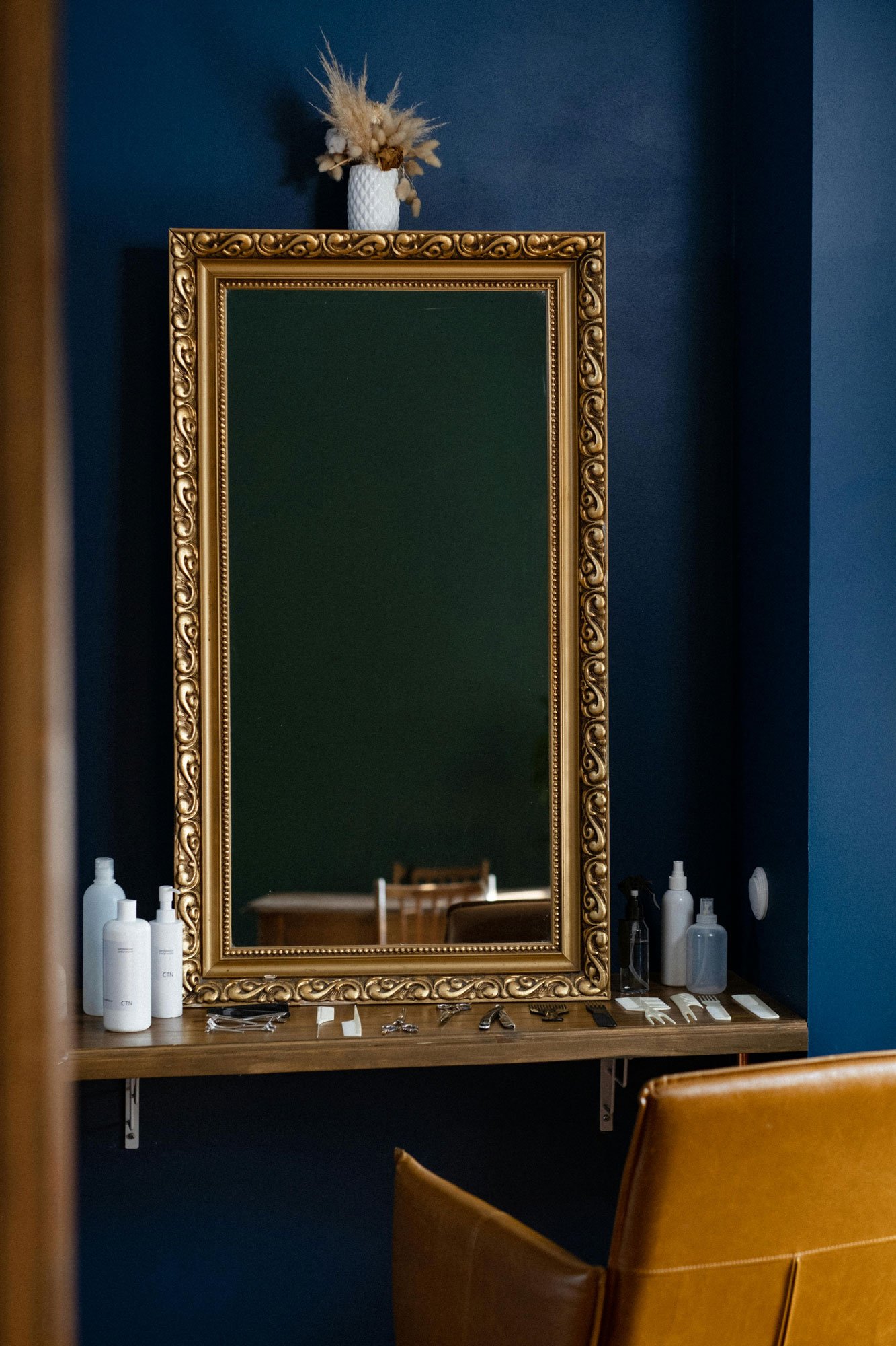 Stock photo of a large mirror framed in an ornate gold frame, illustrating custom mirror framing services.