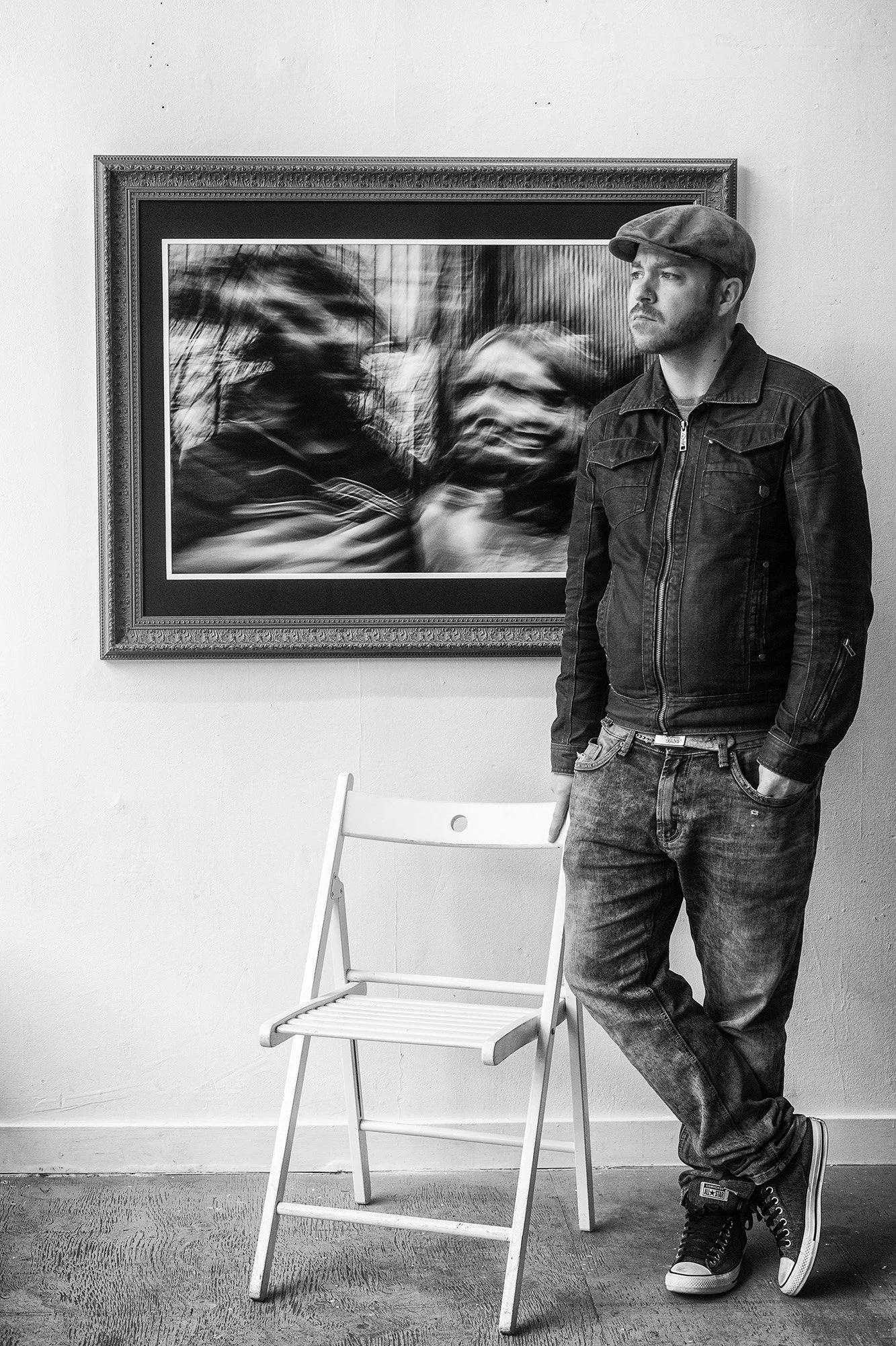 Portrait of Andrew Legere, founder of Legere Fine Art Services, standing in front of a framed photograph in a Vancouver gallery.