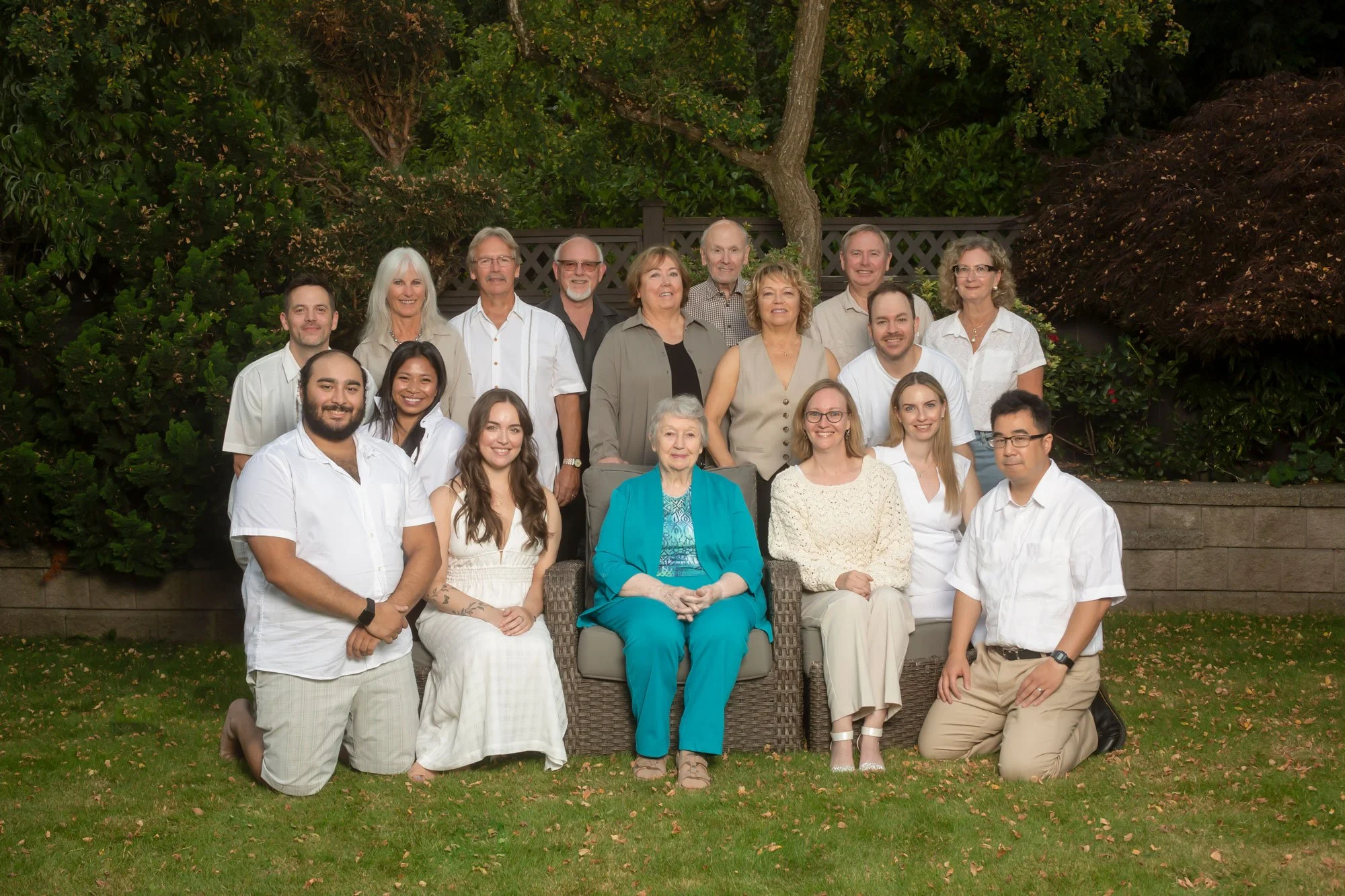 Large family portrait taken outdoors, with multiple family members posed together and smiling at the camera.