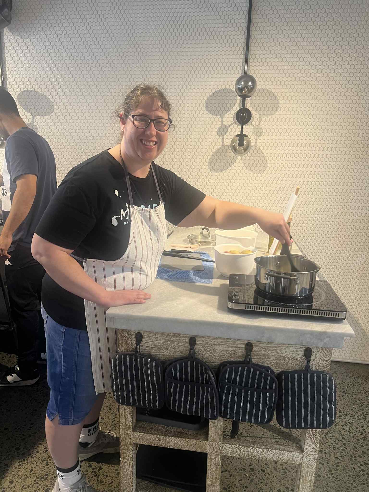 NDIS participant cooking in a kitchen with support, building daily living skills and independence in a supported environment.