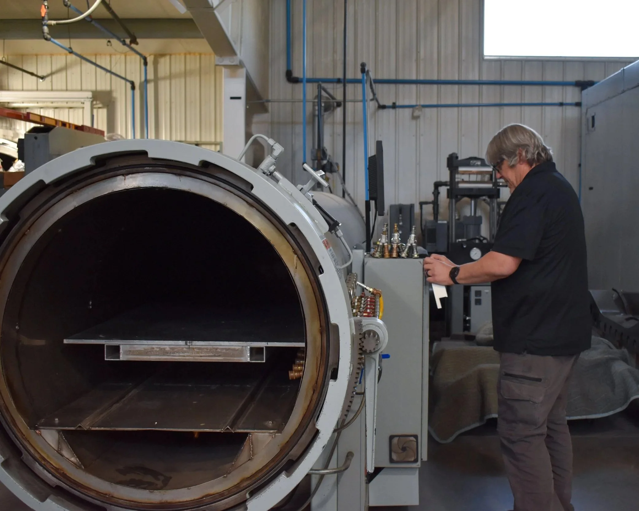 A person operating a large industrial machine in a factory or workshop setting.