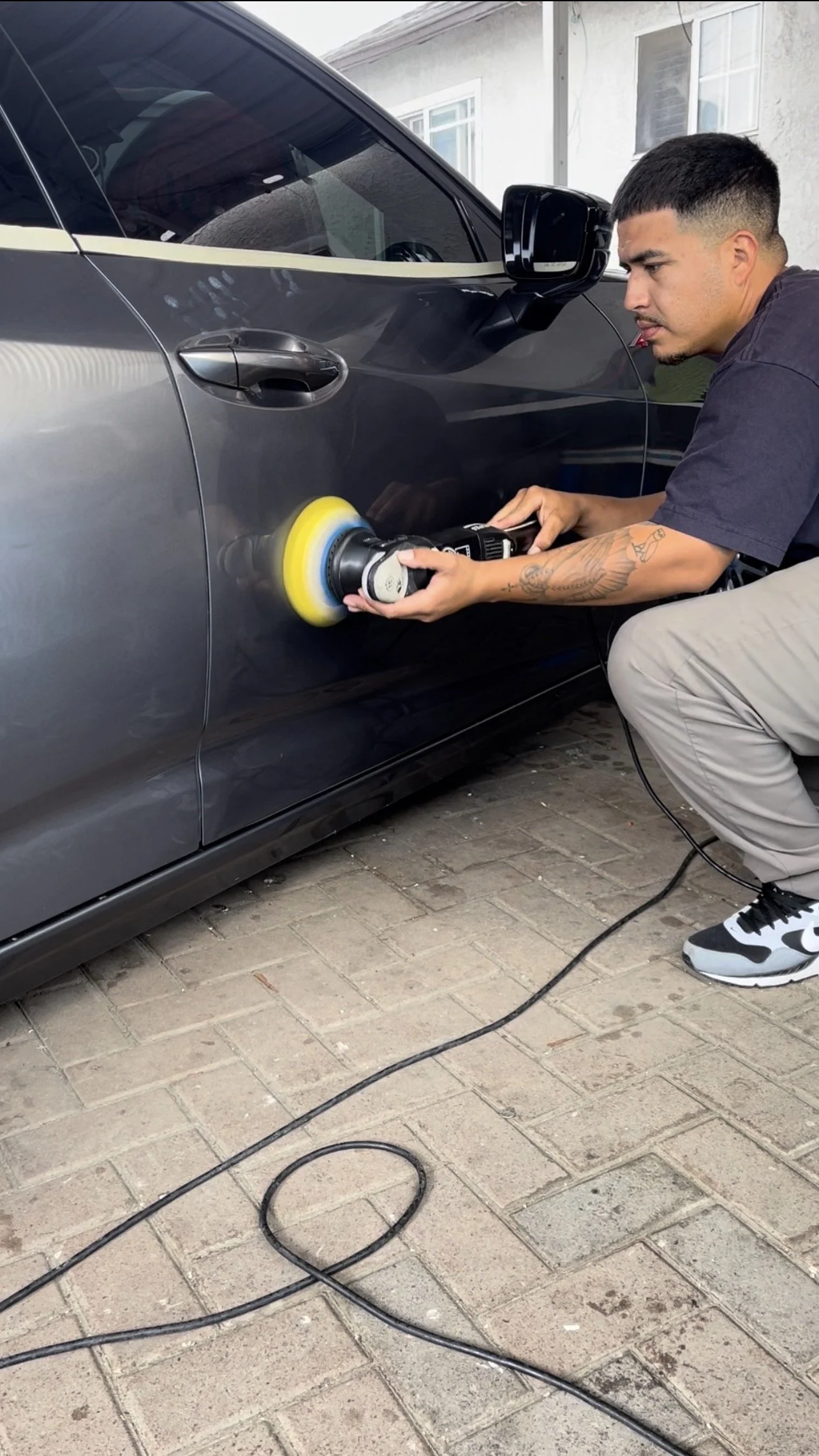 Auto detailer polishing an Acura TLX before applying ceramic coating