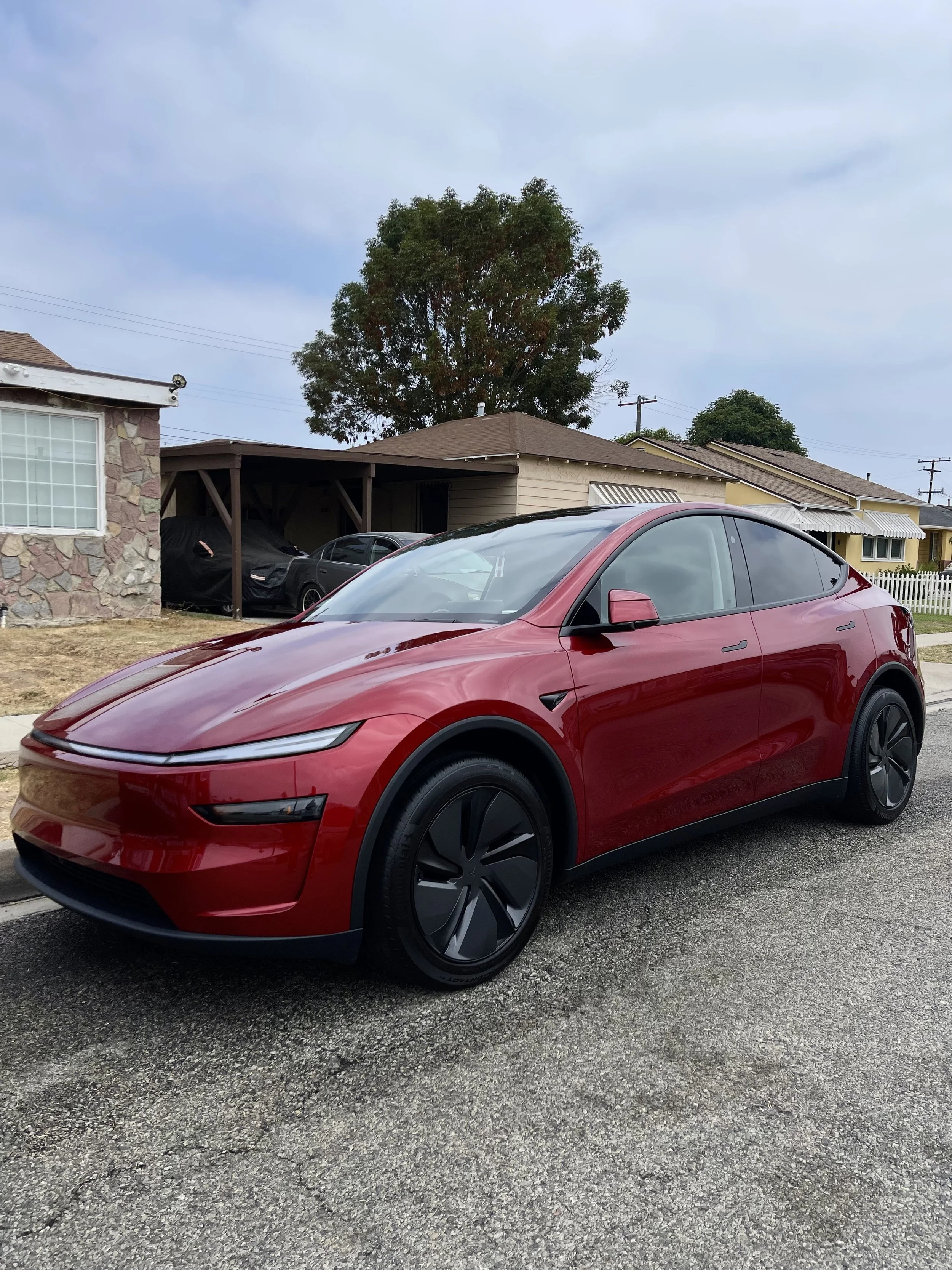 Red Tesla Model Y parked on a residential street after professional mobile car detailing in Los Angeles