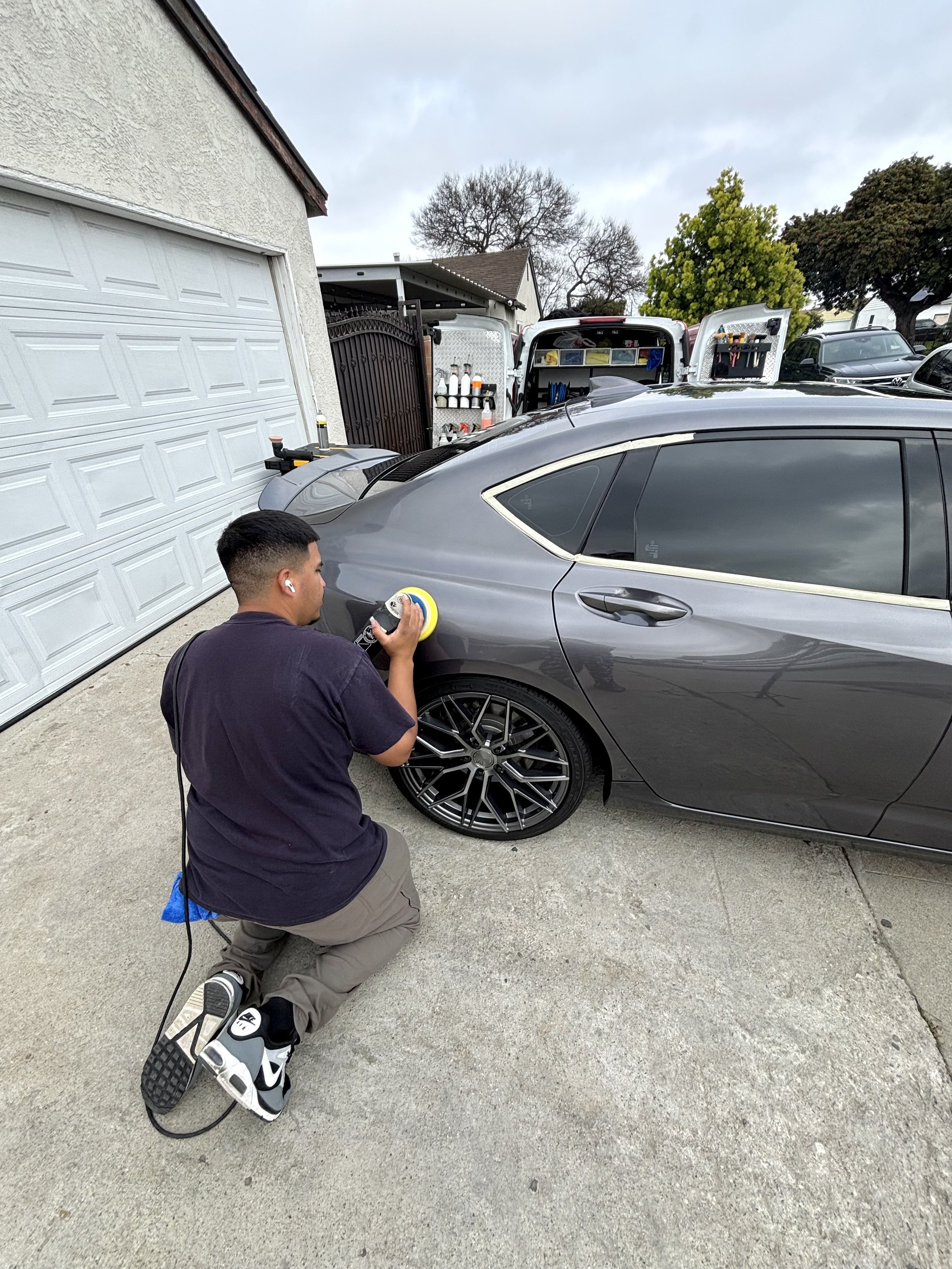 Exterior paint correction service being done on a gray sedan in Los Angeles.