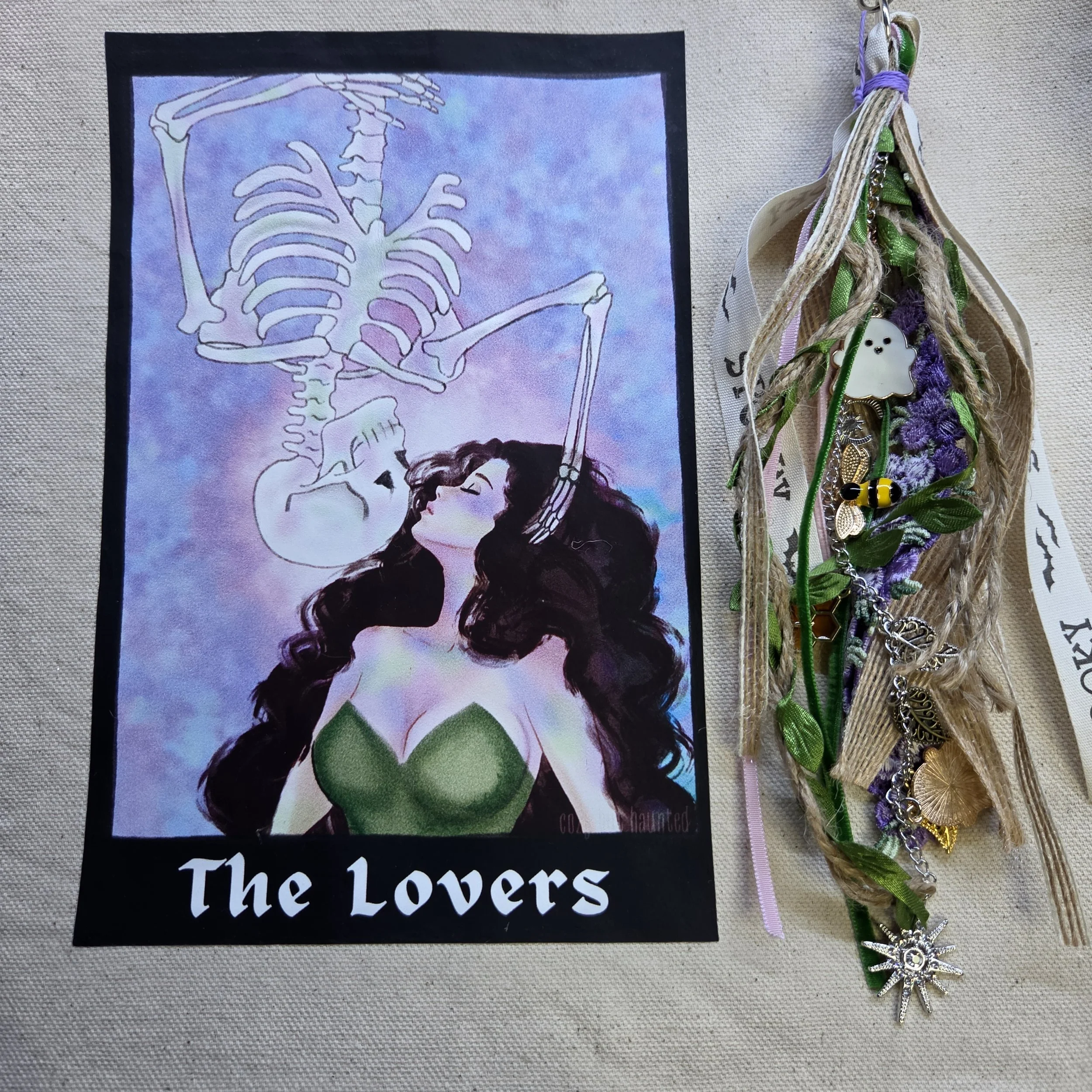 canvas tote bag with a tarot-style drawing of a woman kissing an upside-down skeleton descending toward her with a unique charm.