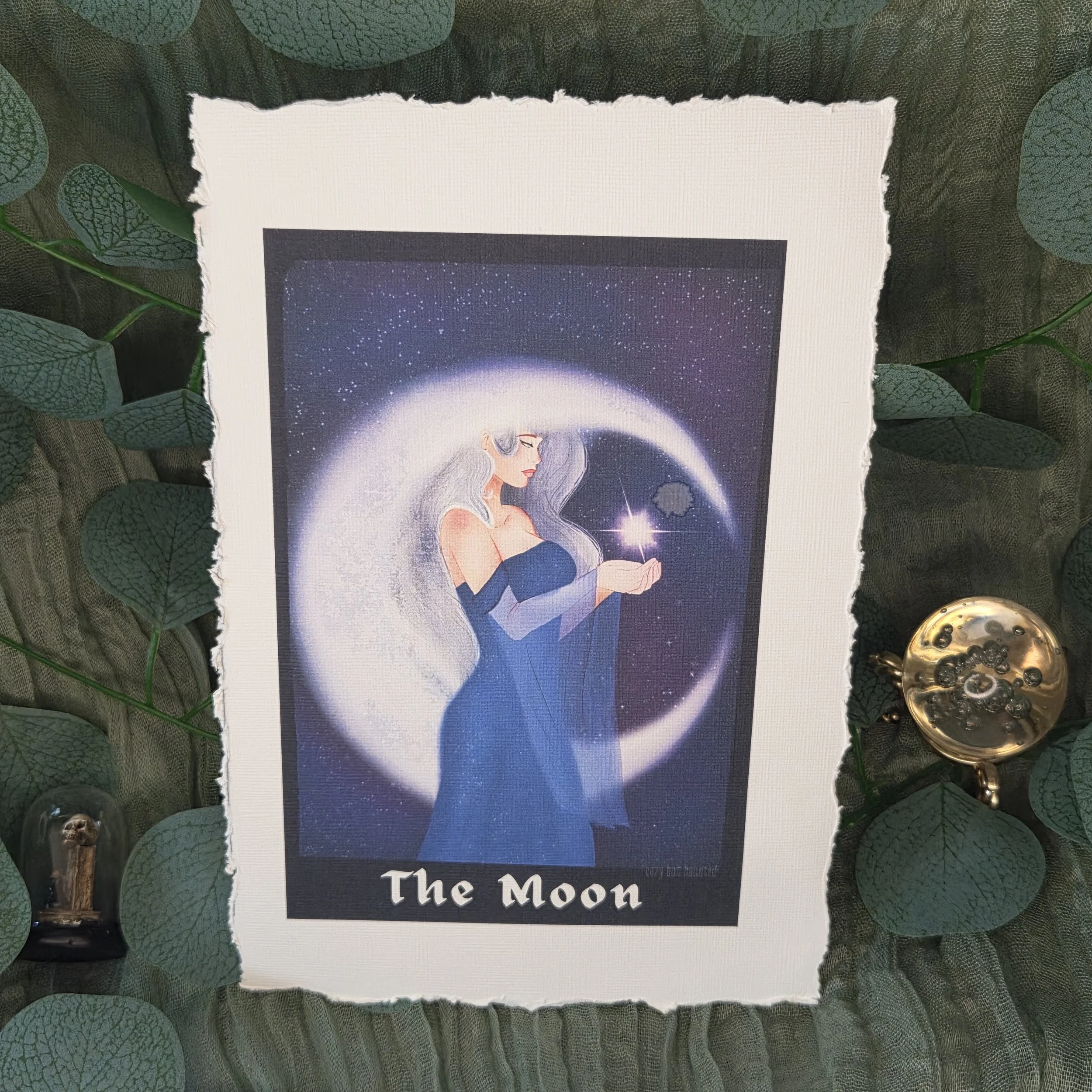 Tarot-style drawing of a woman standing in front of a glowing moon with deep blue night tones on linen textured card stock with deckled edging.
