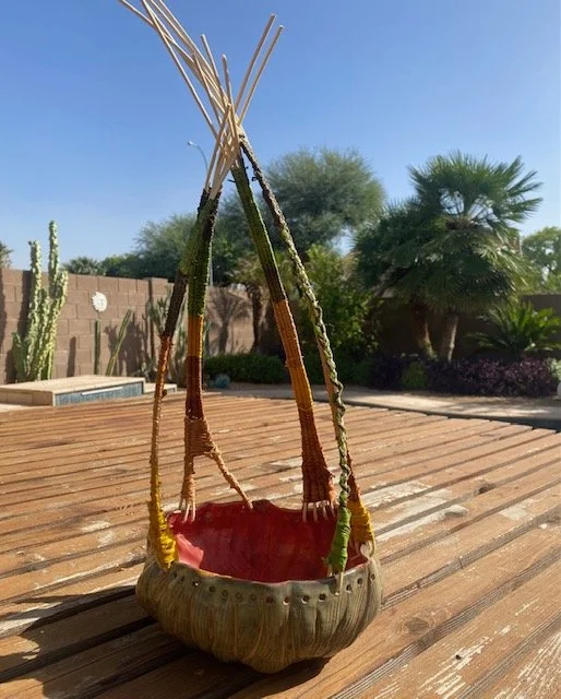 Handmade pottery with woven components on a wooden table