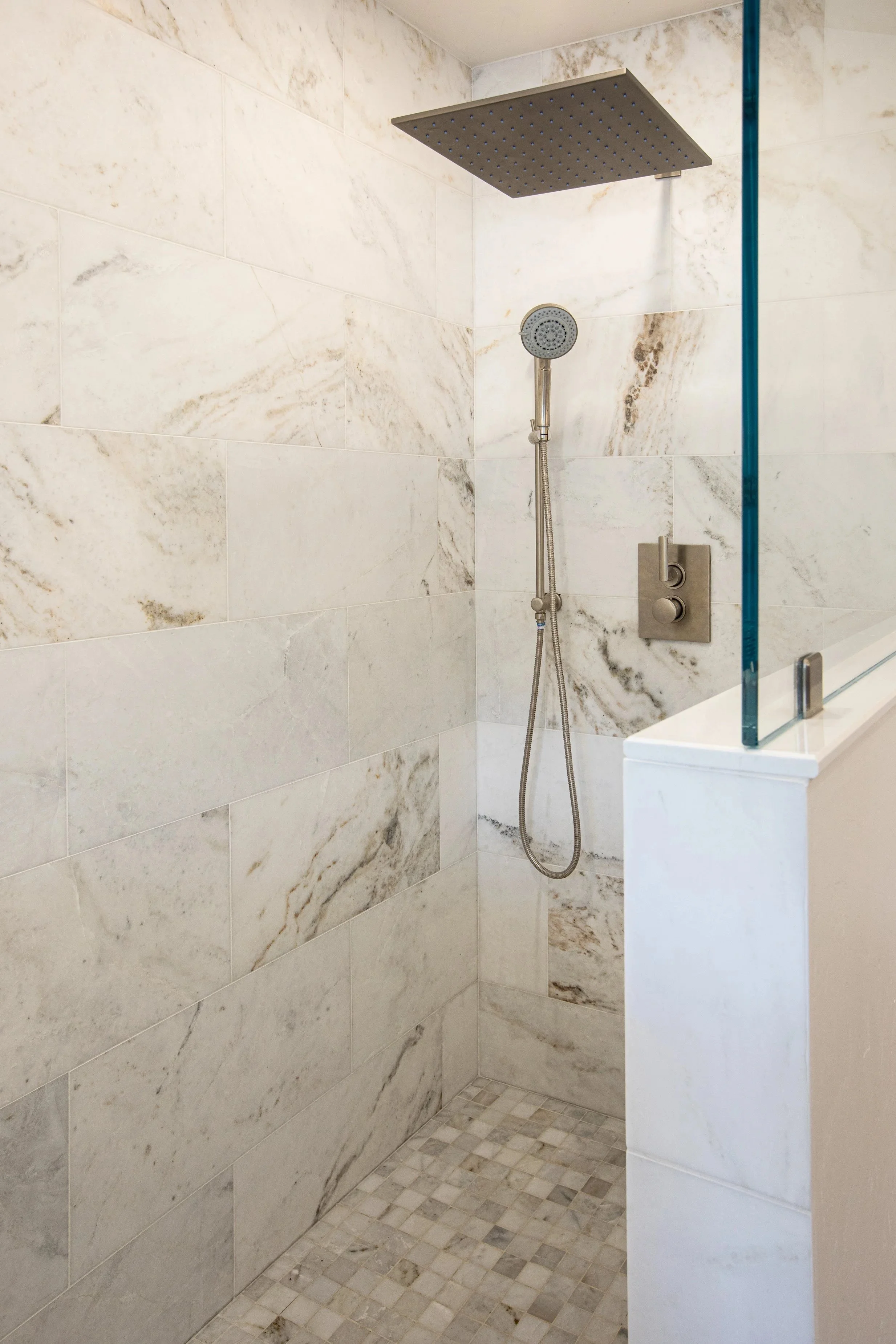 marble tile shower warm ivory brown tones oversized shower head hand shower marble mosaic shower pan 