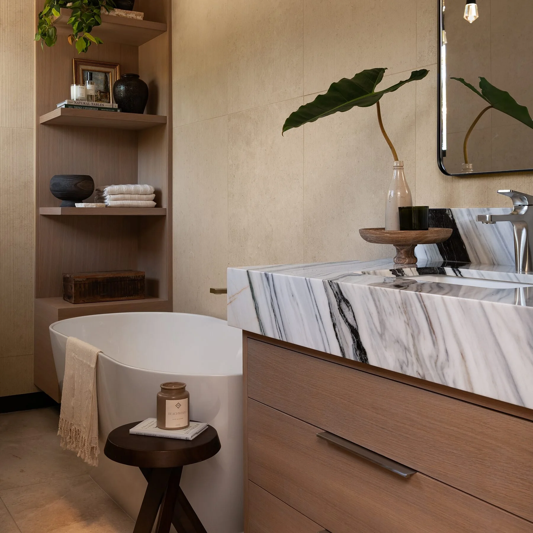 Freestanding soaking tub beside a Bianco Lasa marble vanity in a La Jolla spa bath