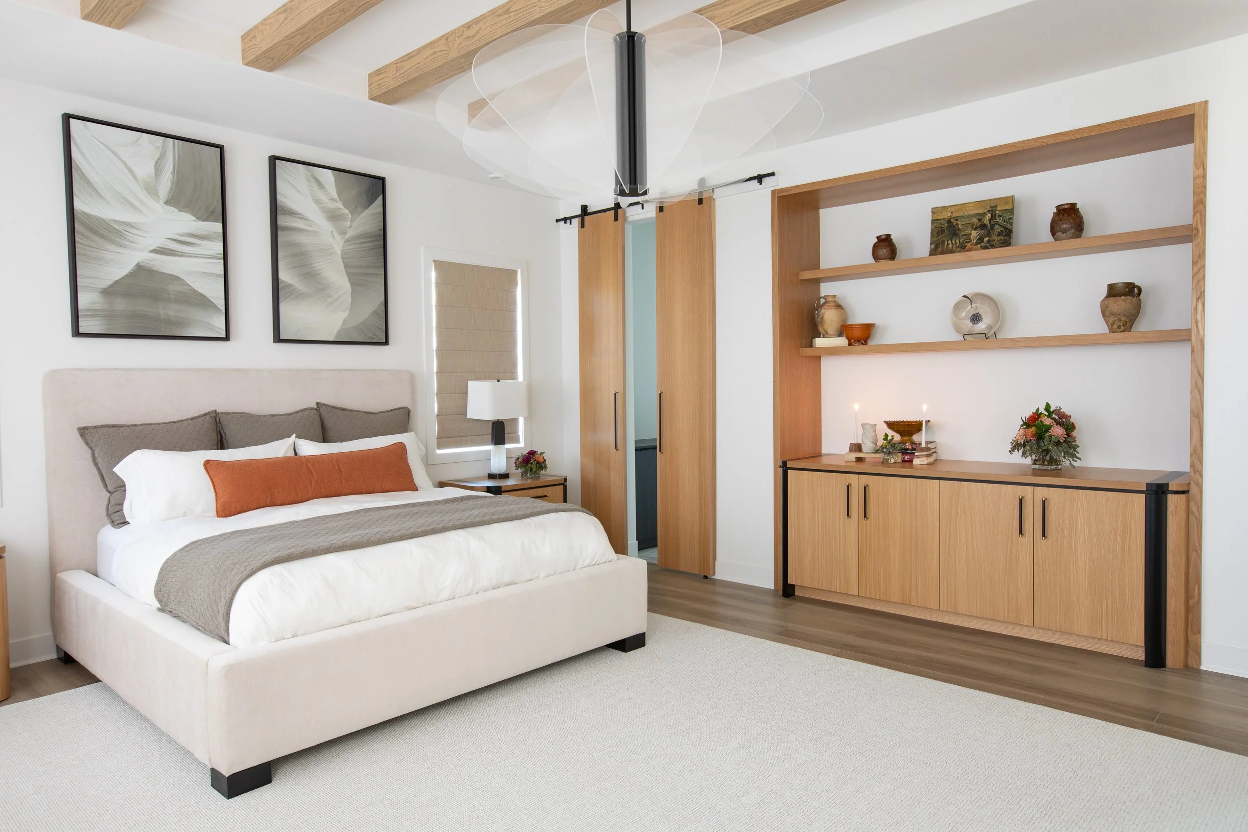 master bedroom upholstered modern bed frame white oak built in shelves wood barn door 