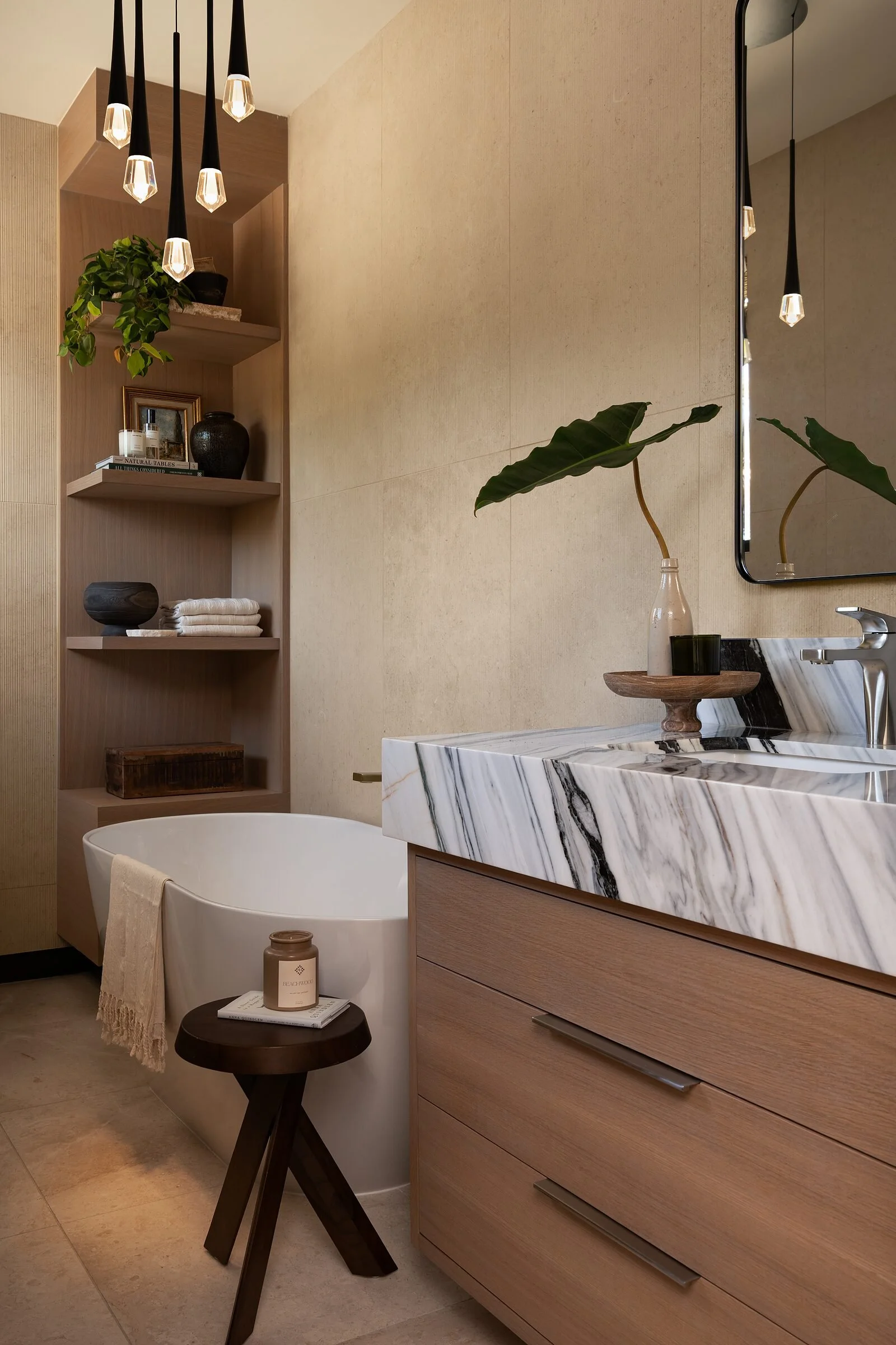 Freestanding soaking tub beside a Bianco Lasa marble vanity in a La Jolla spa bath