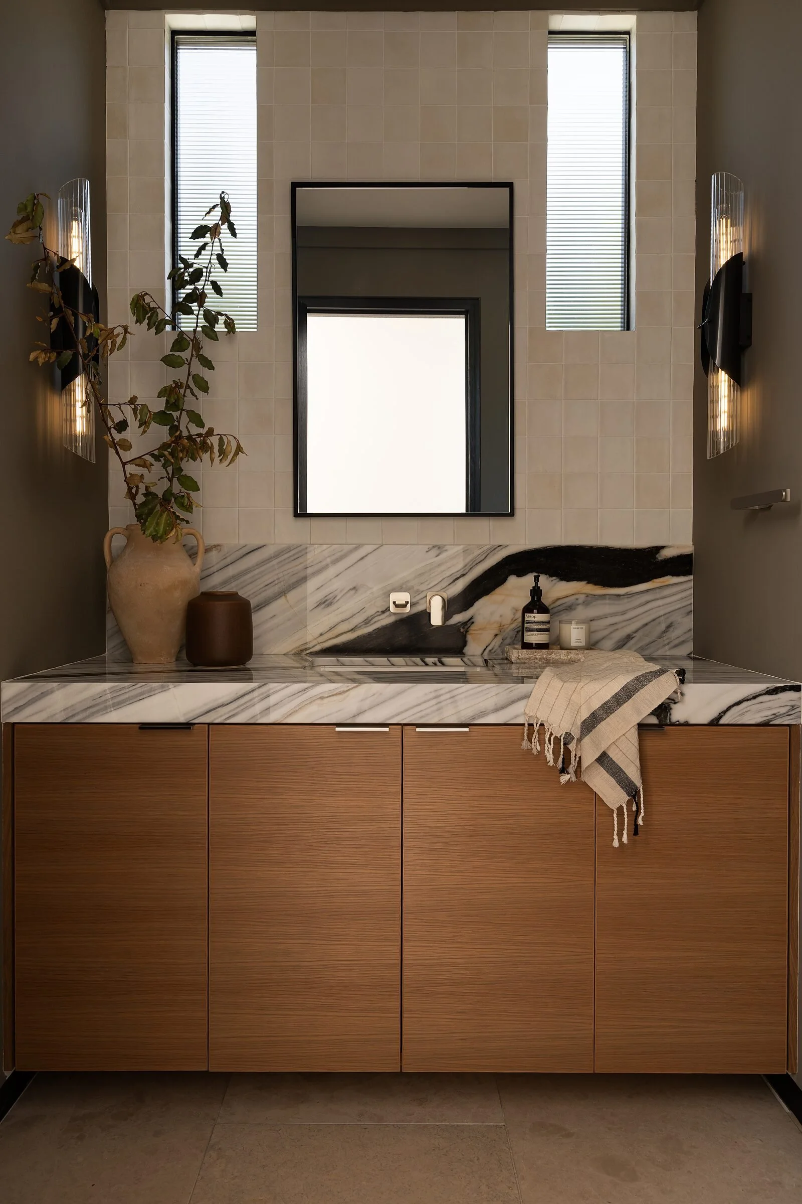 Walnut vanity beneath a Bianco Lasa marble backsplash in a La Jolla powder room