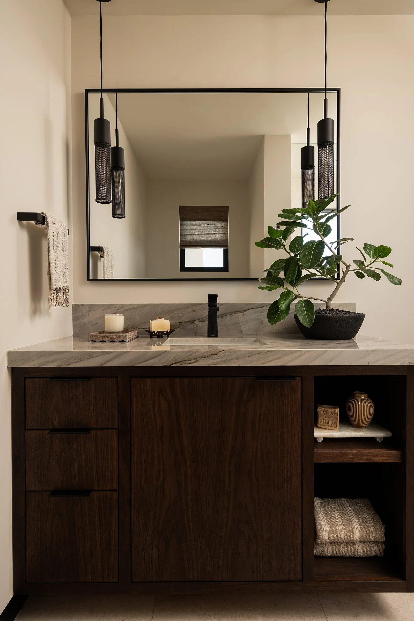 Walnut vanity with Silver Moon quartzite counter and black pendants in the son's bath